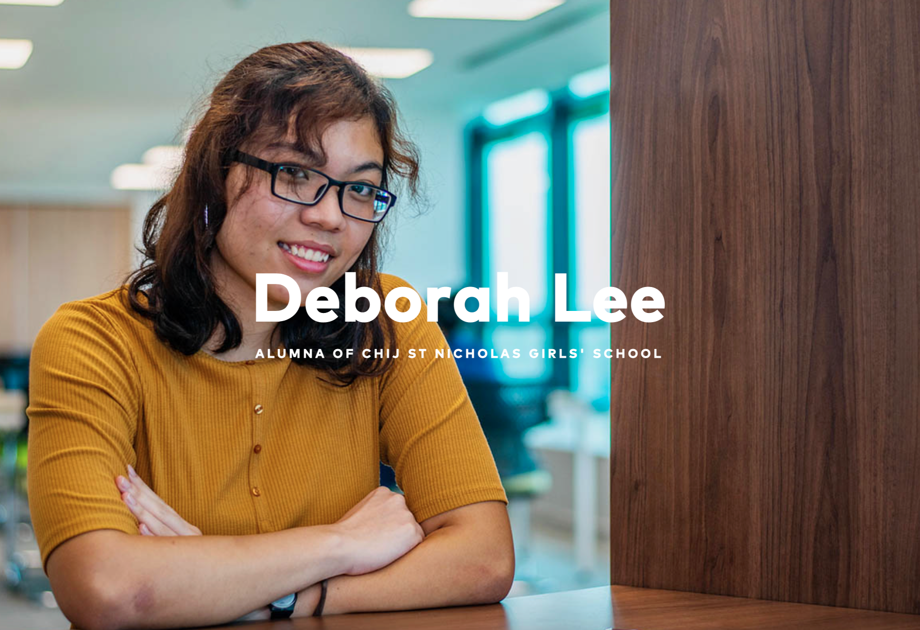 Deborah Lee, alumna of CHIJ St Nicholas Girls' School, smiling with arms crossed in a bright room.
