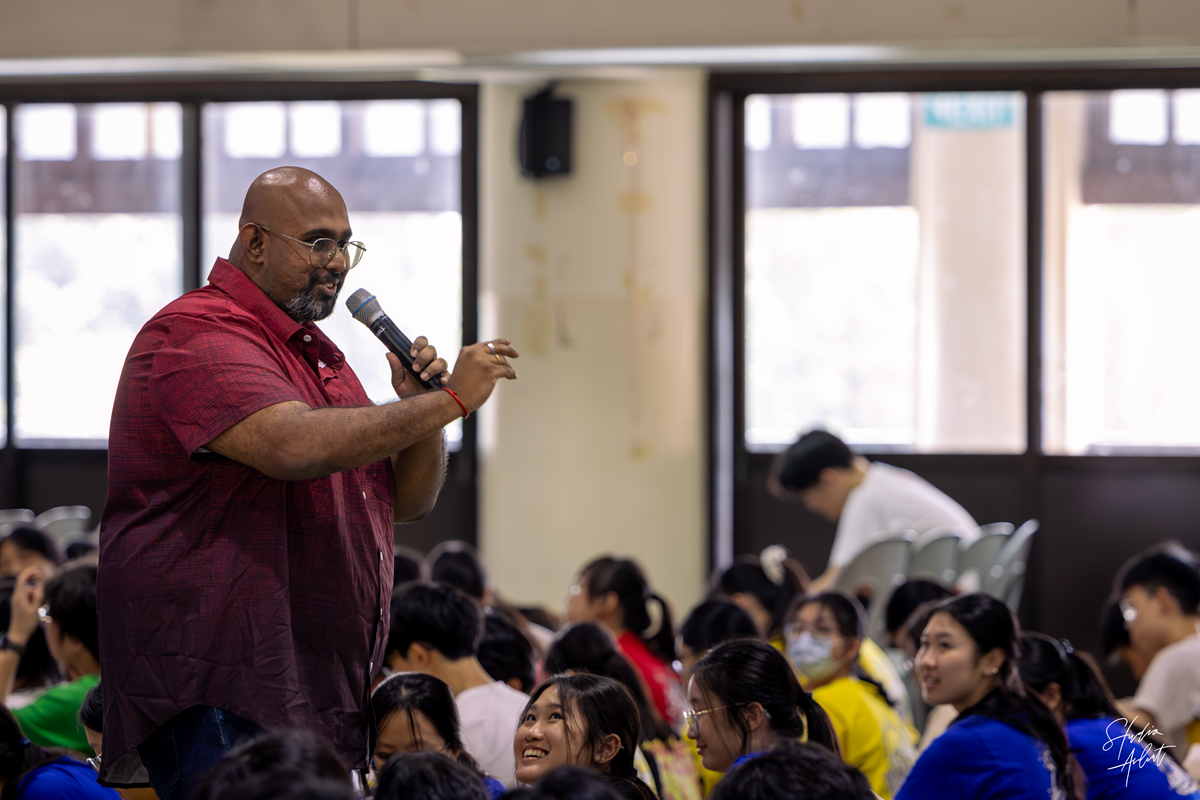 Guest speaker Niranjan Pandian stepping off the stage to interact directly with C2 students during the sharing segment.