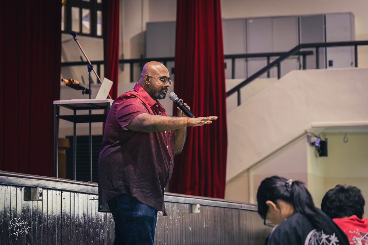 Guest speaker Niranjan Pandian addressing the C2 cohort from the stage edge during his sharing session.