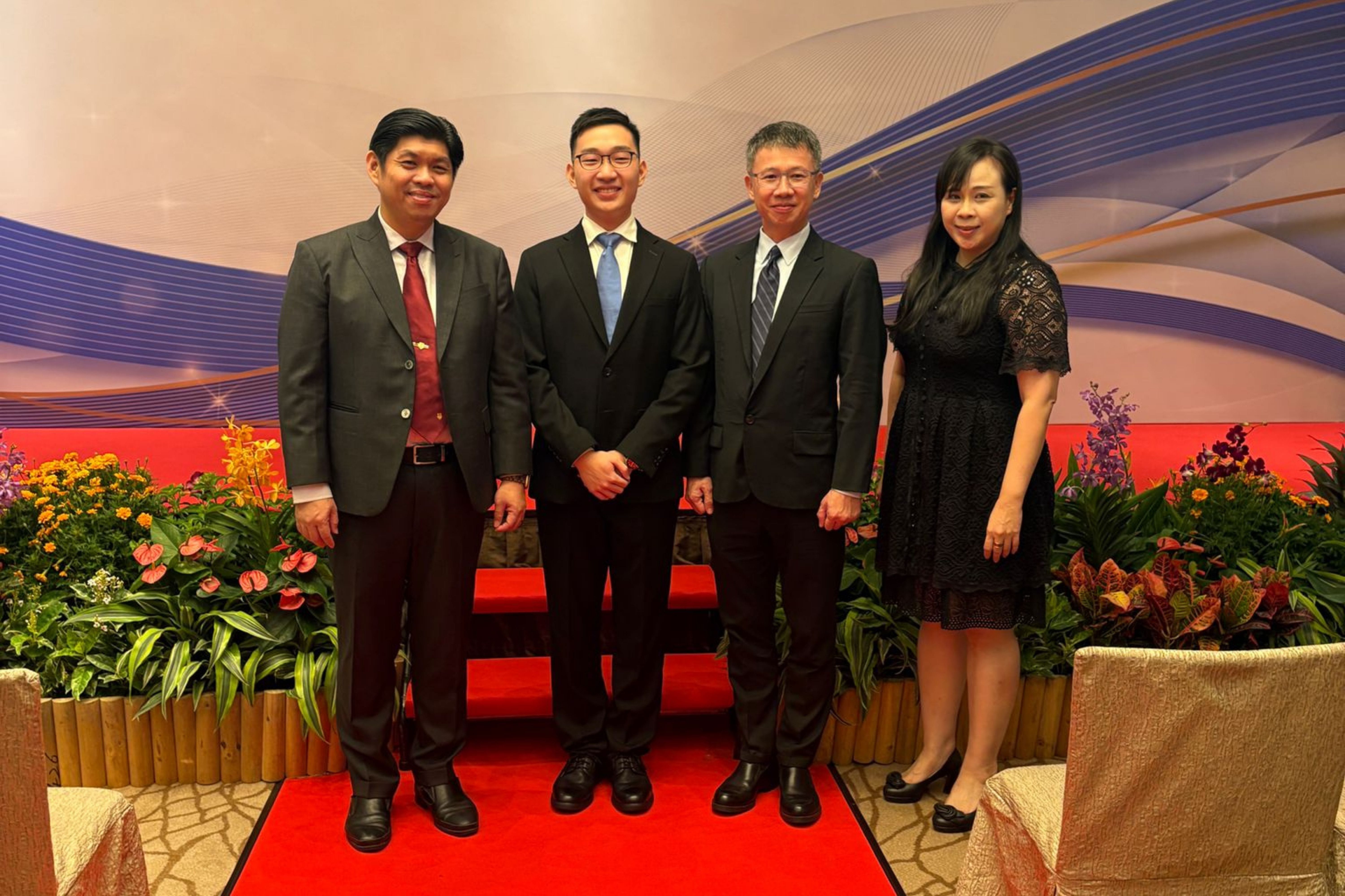 Kaleb taking picture with P and VPs of Hwa Chong Institution on stage during the event