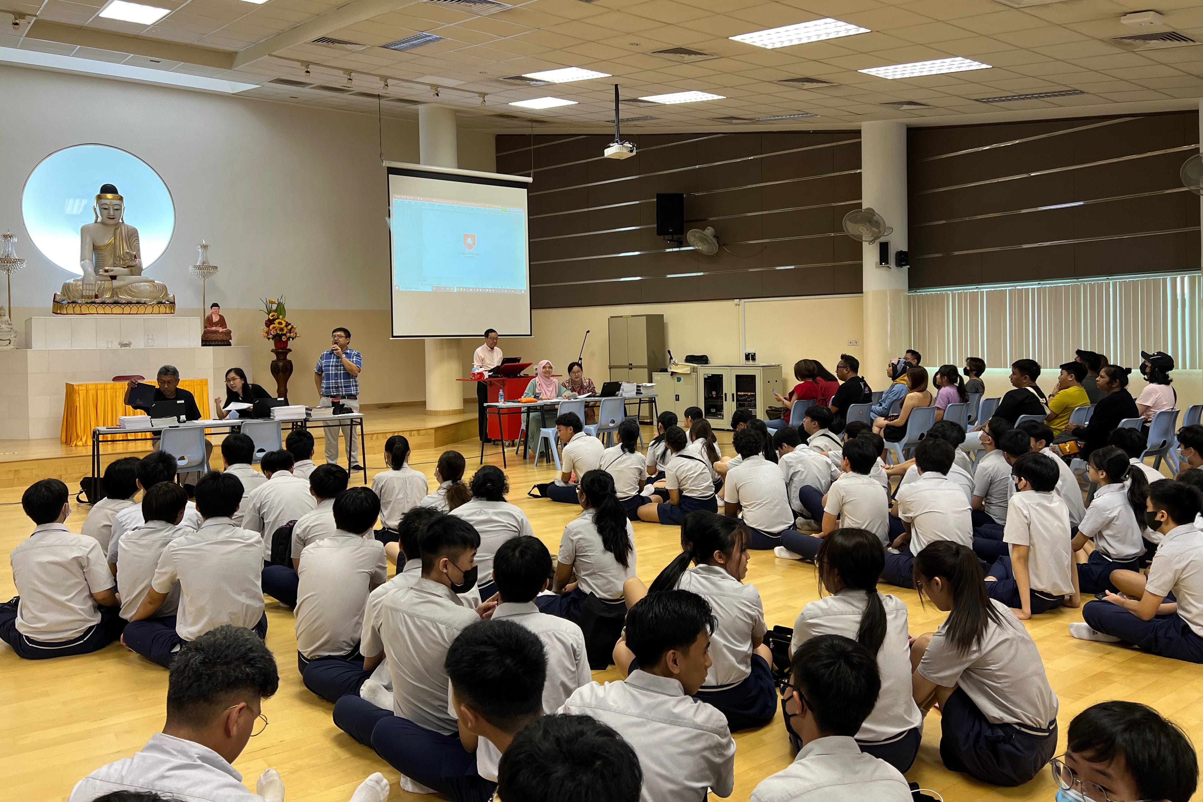 Students attend an examination results briefing with staff and family members.