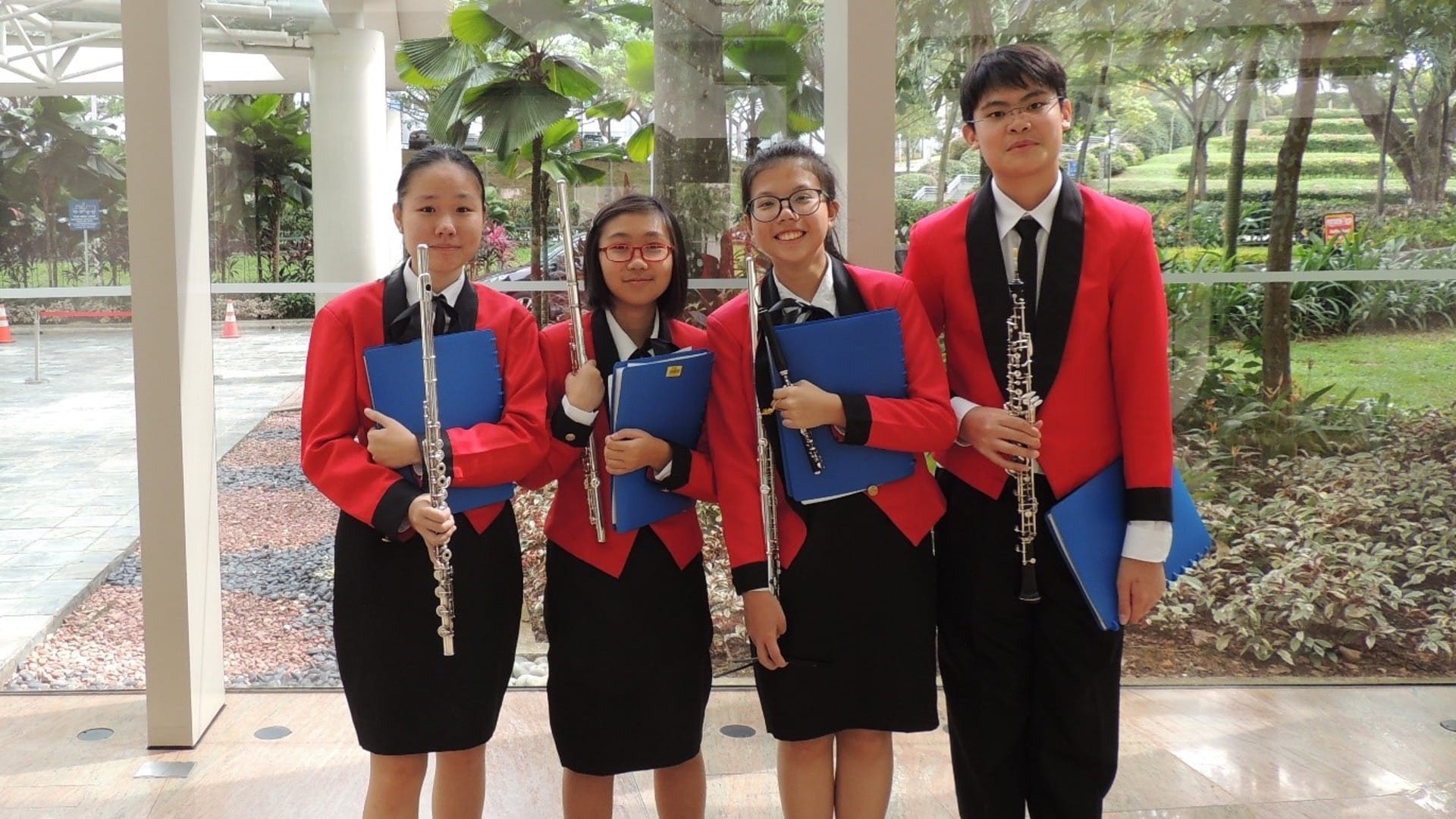 4 band members taking a group photo with their flute instruments