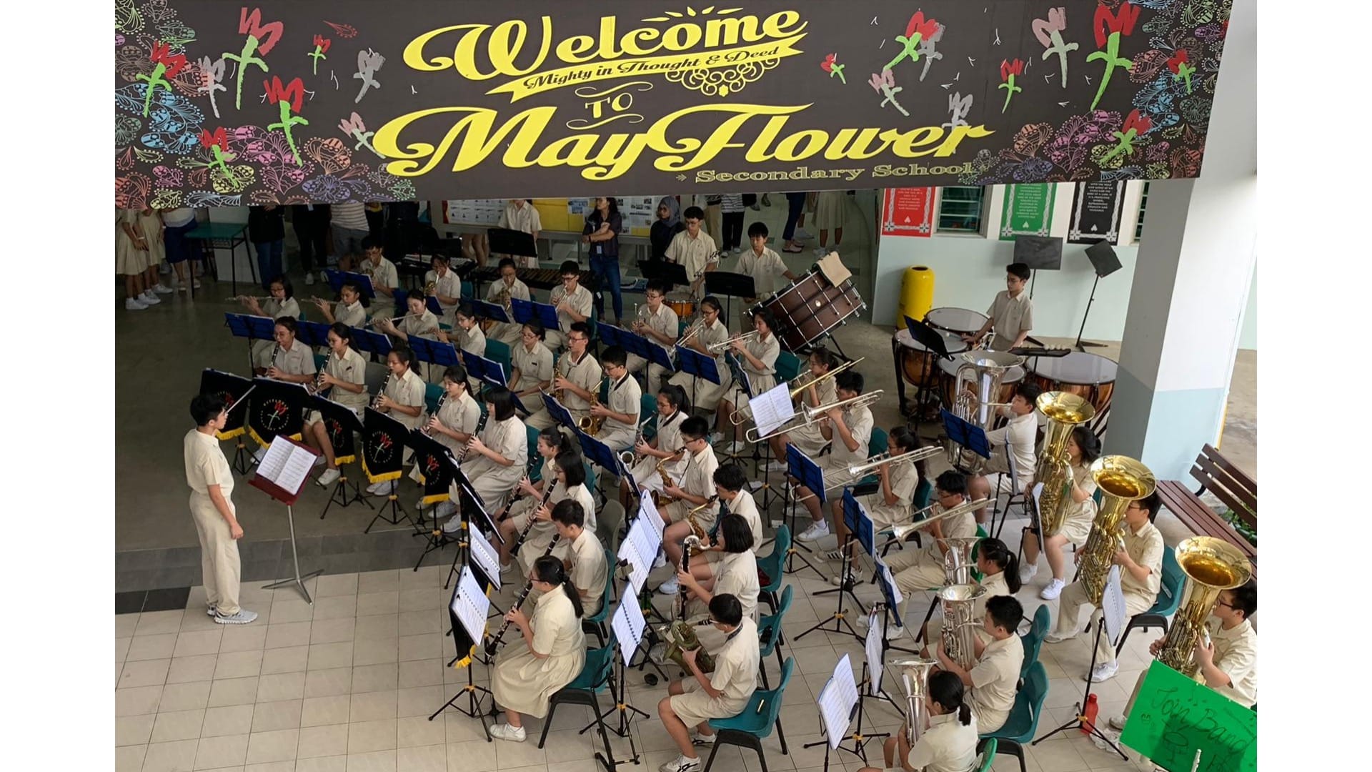 Concert band performance at the school foyer, with student as the conductor
