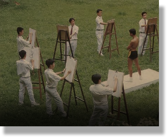 Several young male students in white clothes draw on easels outdoors, sketching a shirtless male model standing on a platform.
