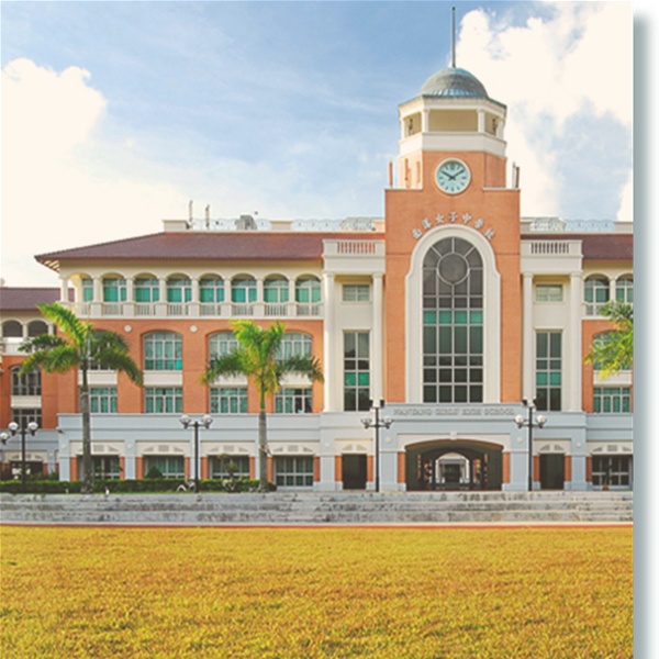 Large red and white school building with a clock tower, palm trees, and a green lawn in front.