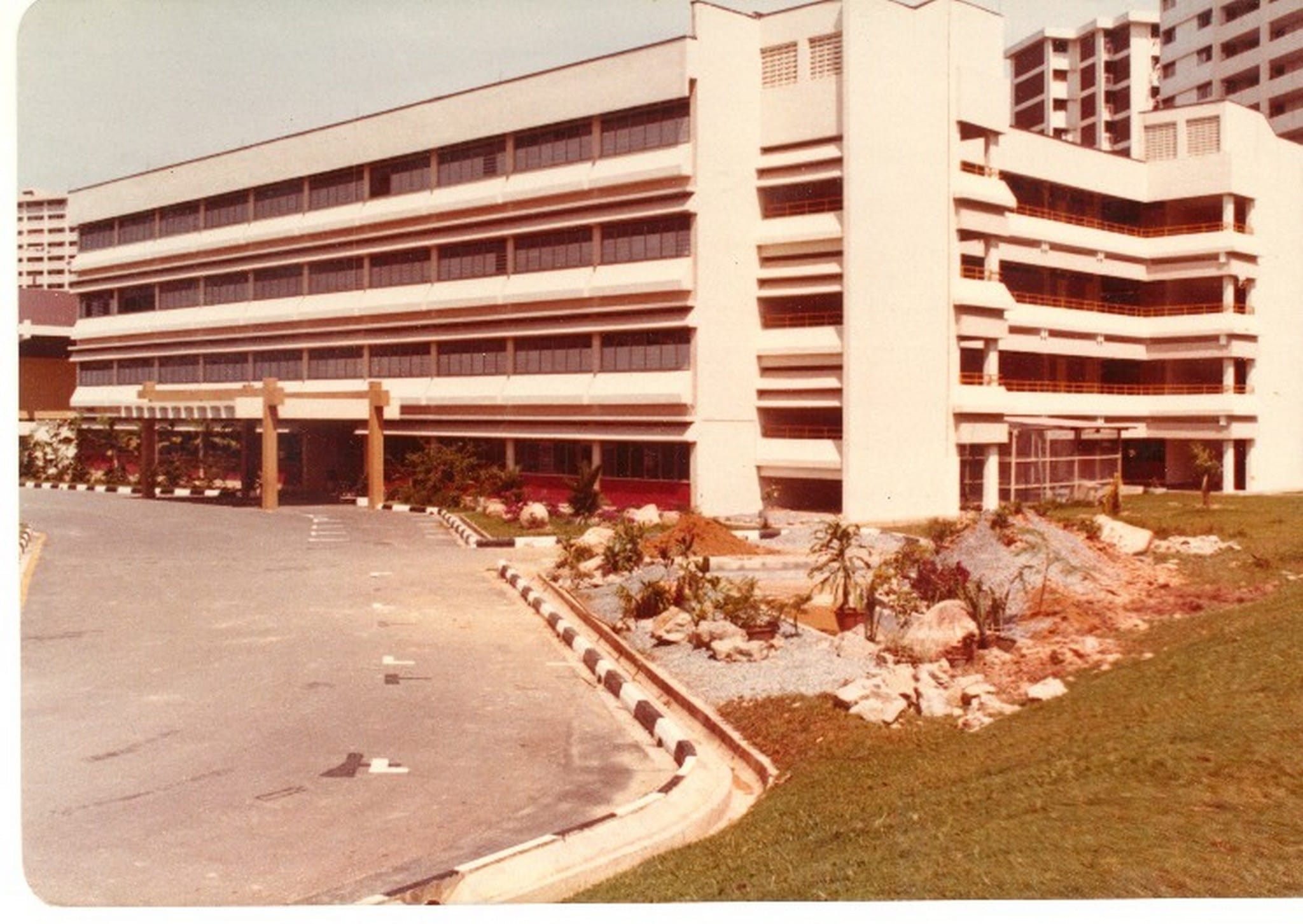Depicts the photo of the first school campus with the ongoing construction of the school pond and aviary (1980)