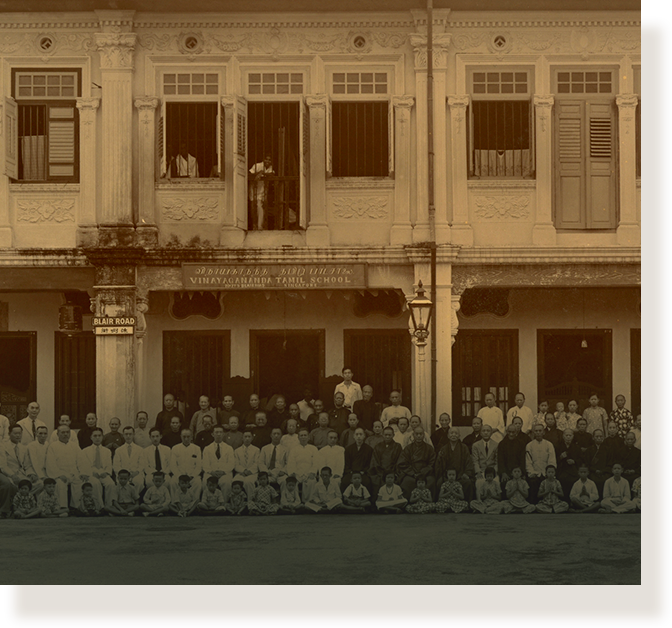 Large group posed in front of Vinayagamenda Tamil School on Blair Road in a sepia-toned historic photo.