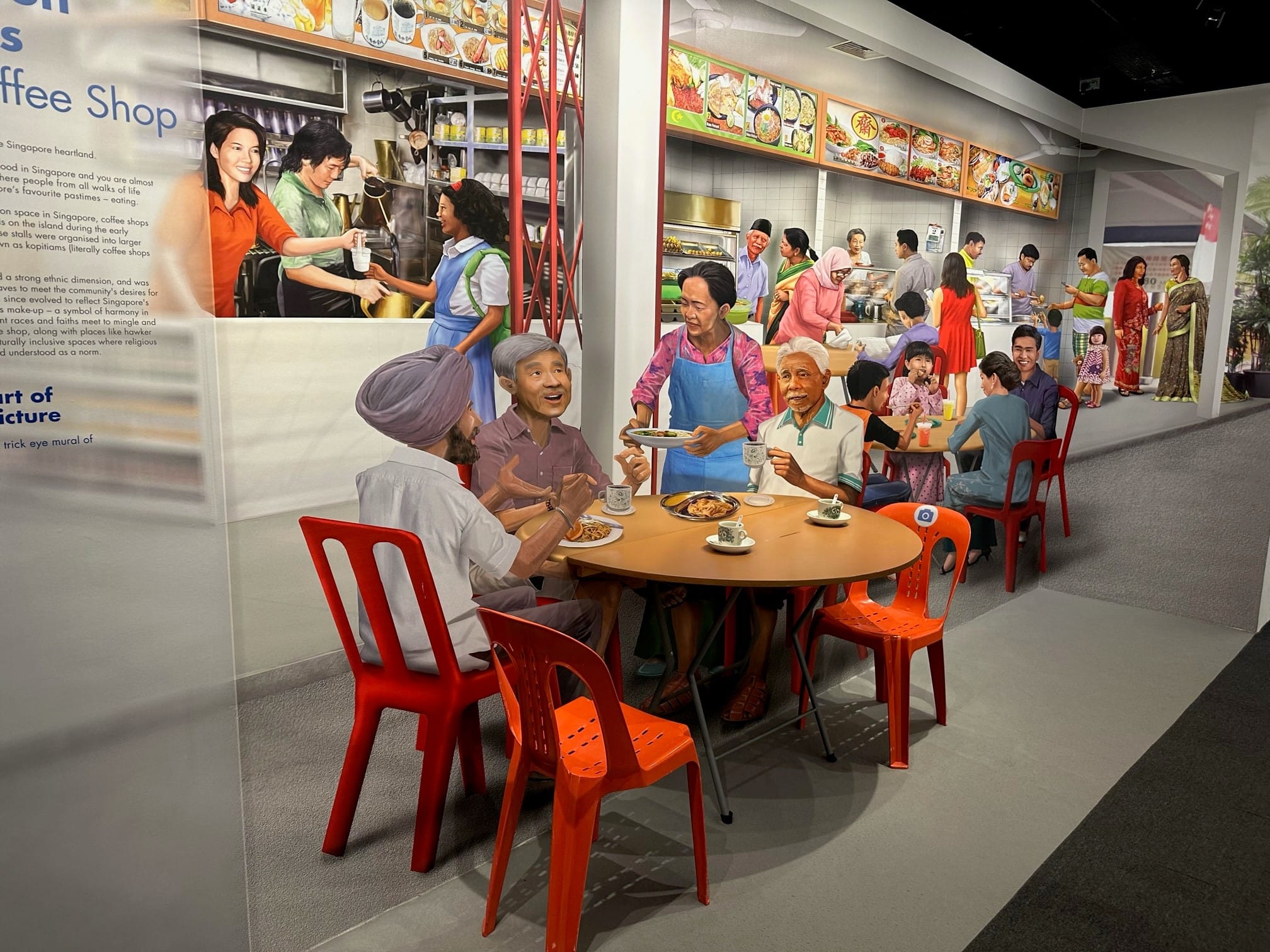 Museum exhibit with a trompe-l'oeil mural of a Singapore coffee shop scene with diverse people dining.