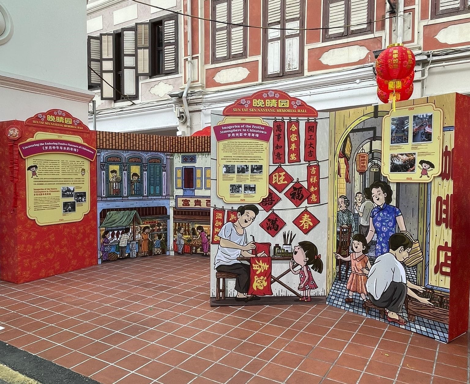 Outdoor display boards with colorful Chinese New Year illustrations and text outside Sun Yat Sen Nanyang Memorial Hall.
