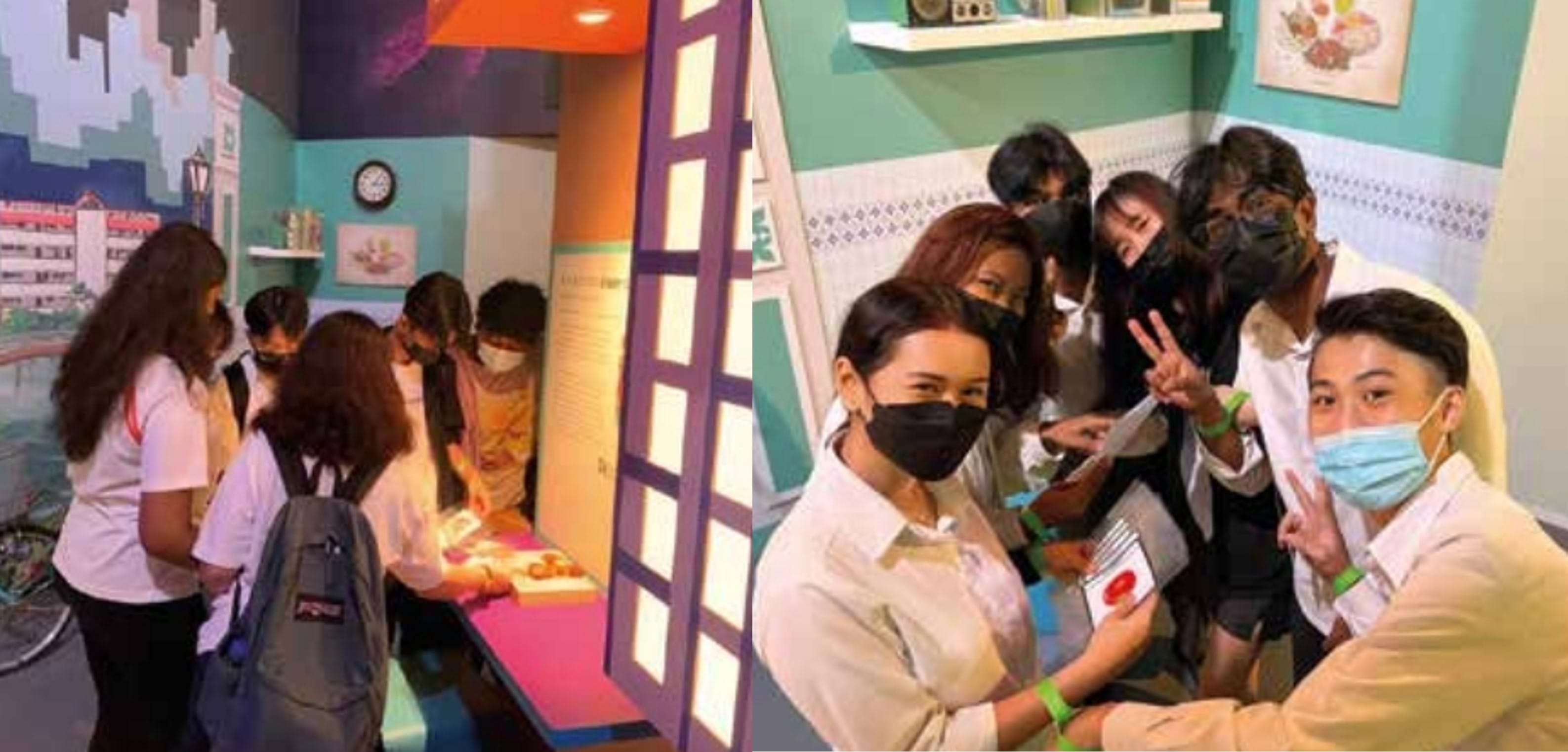 Group of masked young people exploring a colorful museum exhibit, posing and smiling for a photo.