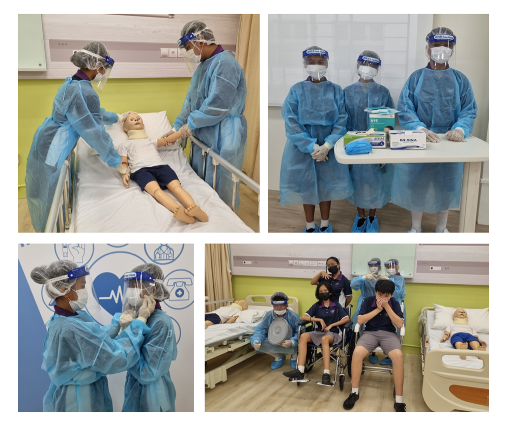 Students in blue PPE gowns and face shields practice medical care on mannequins in a hospital simulation room.