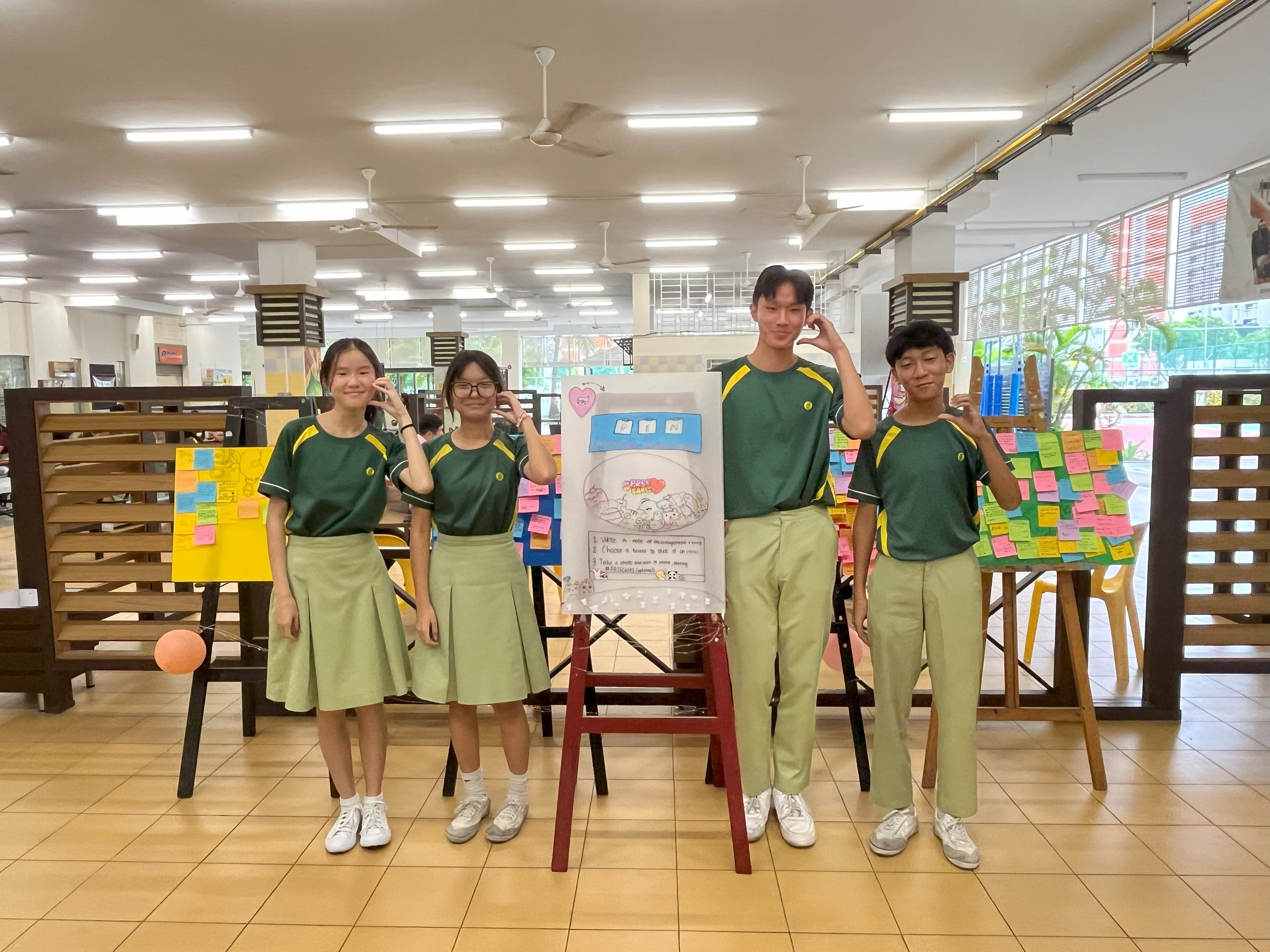 Peer support leaders smiling next to the posters full of post it notes.