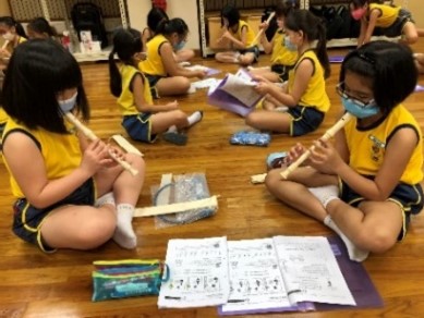 P3 sharing the recorder creation with each other before practising the fingering on recorder together