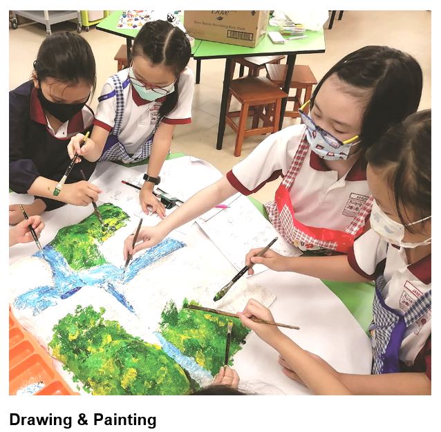 Four masked schoolgirls in uniforms collaboratively painting a large green and blue landscape on white paper.