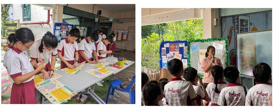 Students in red and white uniforms work on colorful posters at a table, while a teacher presents to seated students outdoors.