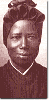 Black and white portrait of a person wearing dark clothing and a head covering, looking forward.