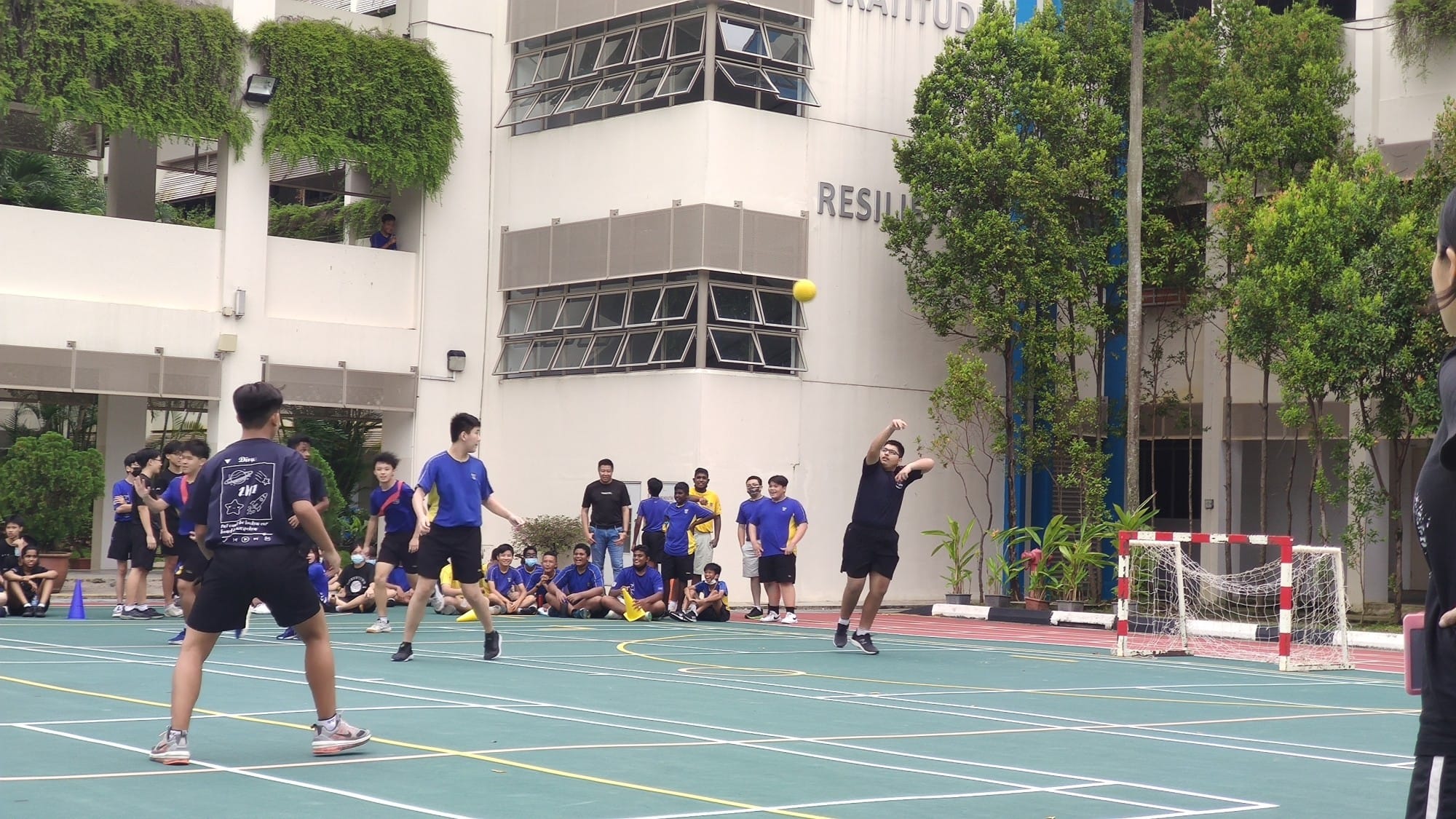 YTzens playing handball at the parade square.