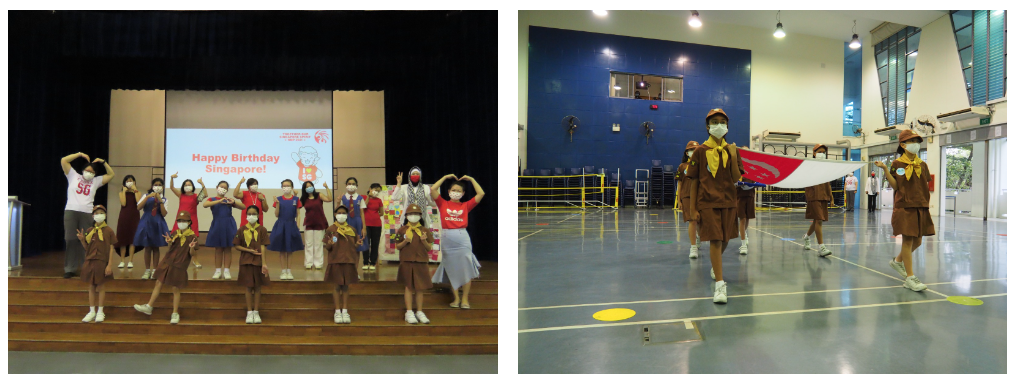 Children in uniforms pose on stage before a Happy Birthday Singapore screen, while scouts march carrying a flag in a gym.
