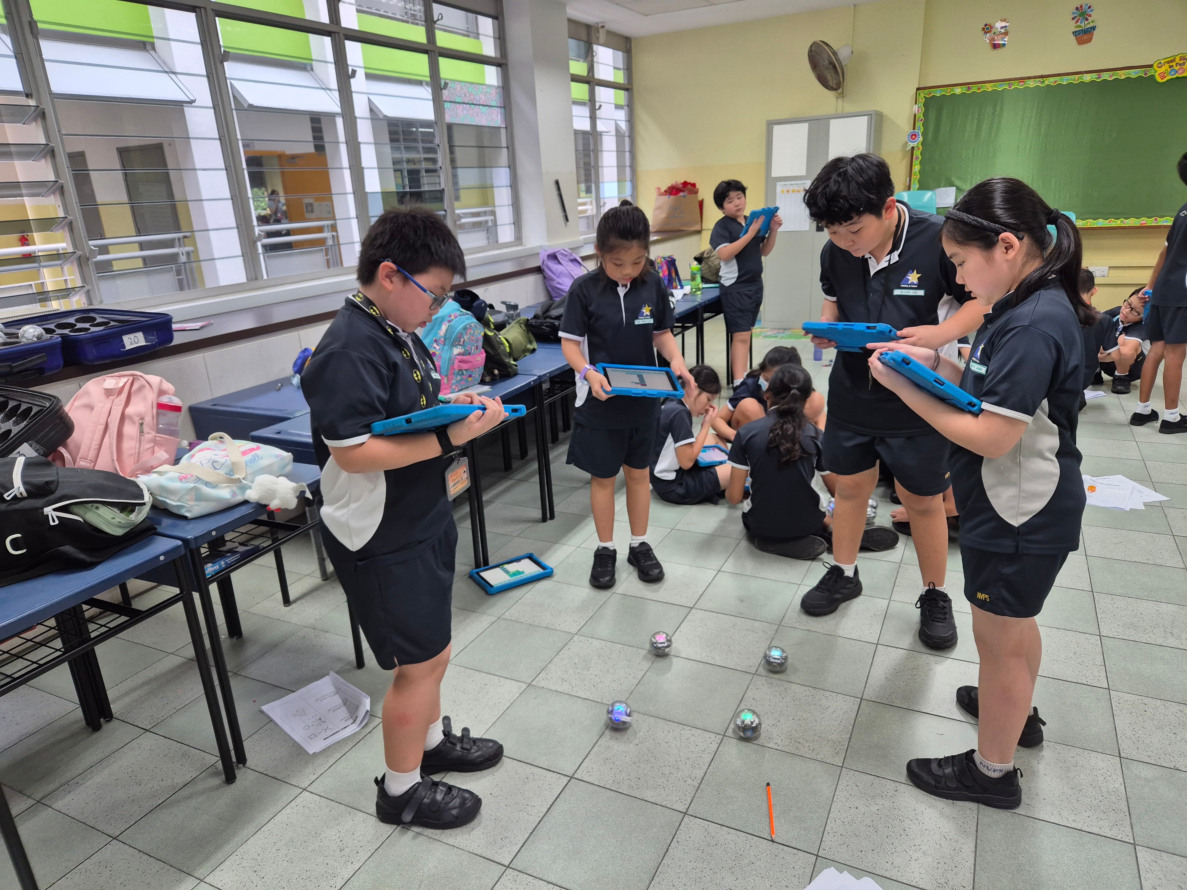 A group of students tests their Sphero robots, observing how the robots move as they collaborate, experiment, and solve coding challenges together.