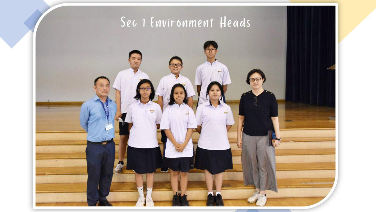 Six students in white uniforms pose with two teachers on wooden steps, labeled Sec 1 Environment Heads.