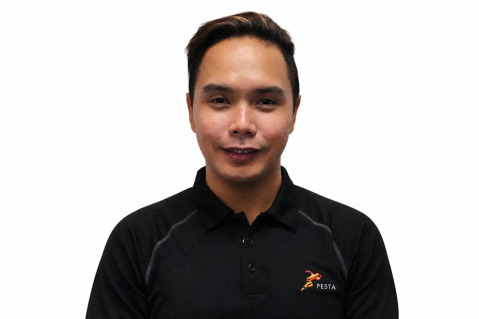 Young man smiling, wearing a black Pesta polo shirt, standing against a light gray wall.