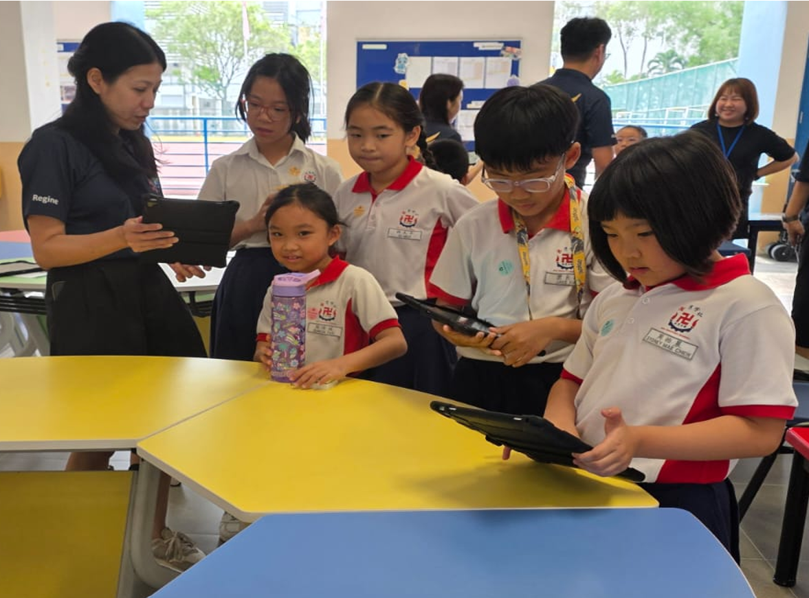 Students using iPads to complete a quiz. They are accompanied by parent volunteers.