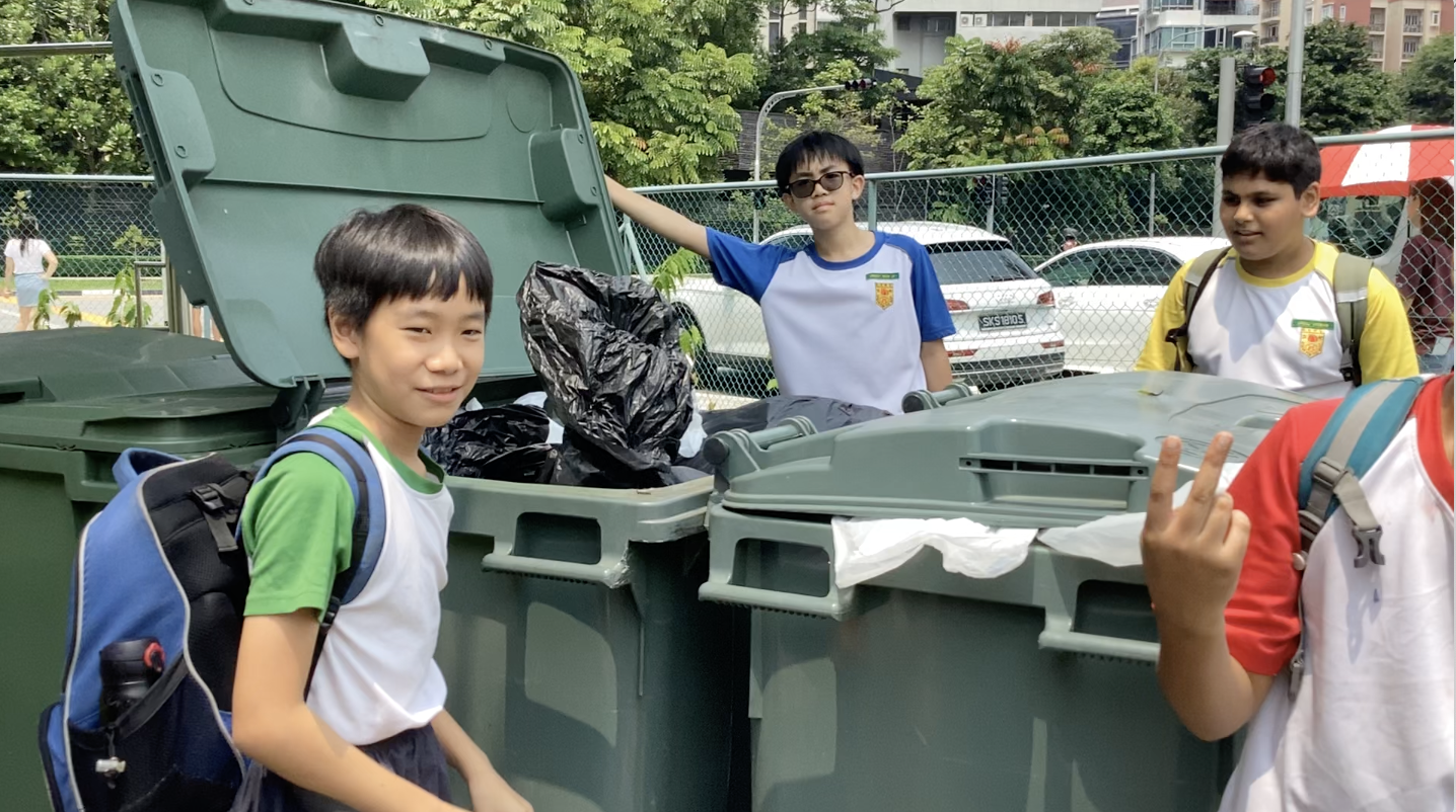 Students seen throwing their rubbish into the green bins.