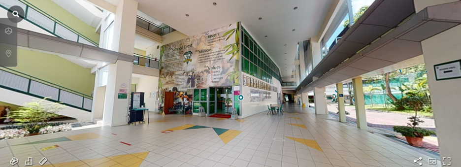 A school lobby with a large mural displaying vision, mission, and values on the wall, with a tiled floor.
