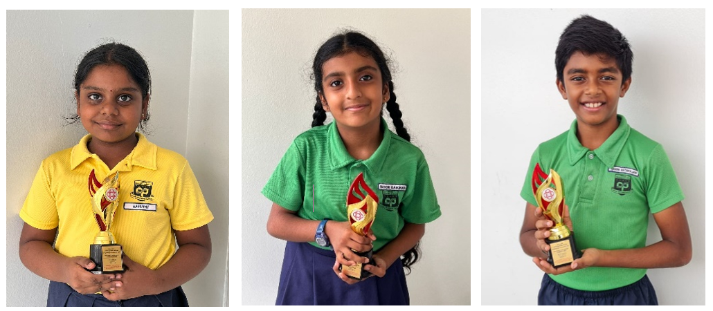 Three children in school uniforms each holding a small trophy, smiling at the camera.