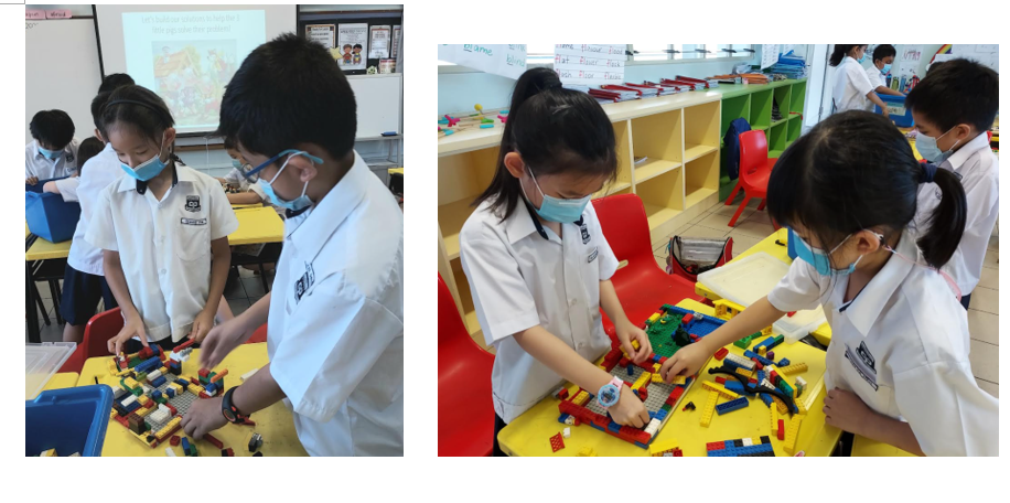 Students in white uniforms and face masks build with colorful LEGO bricks on yellow tables in a classroom.