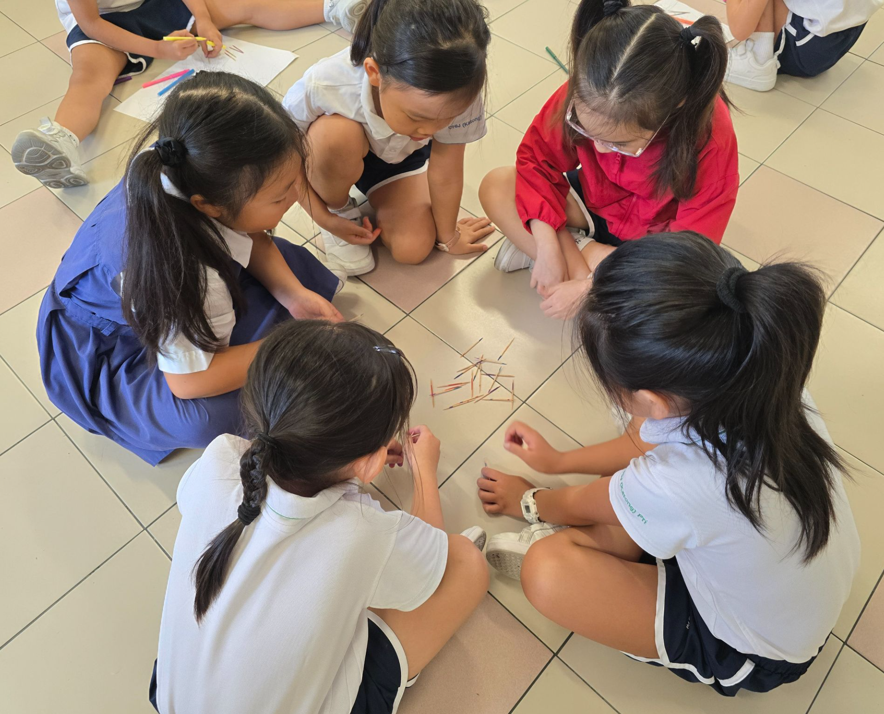 Students playing traditional matchsticks game