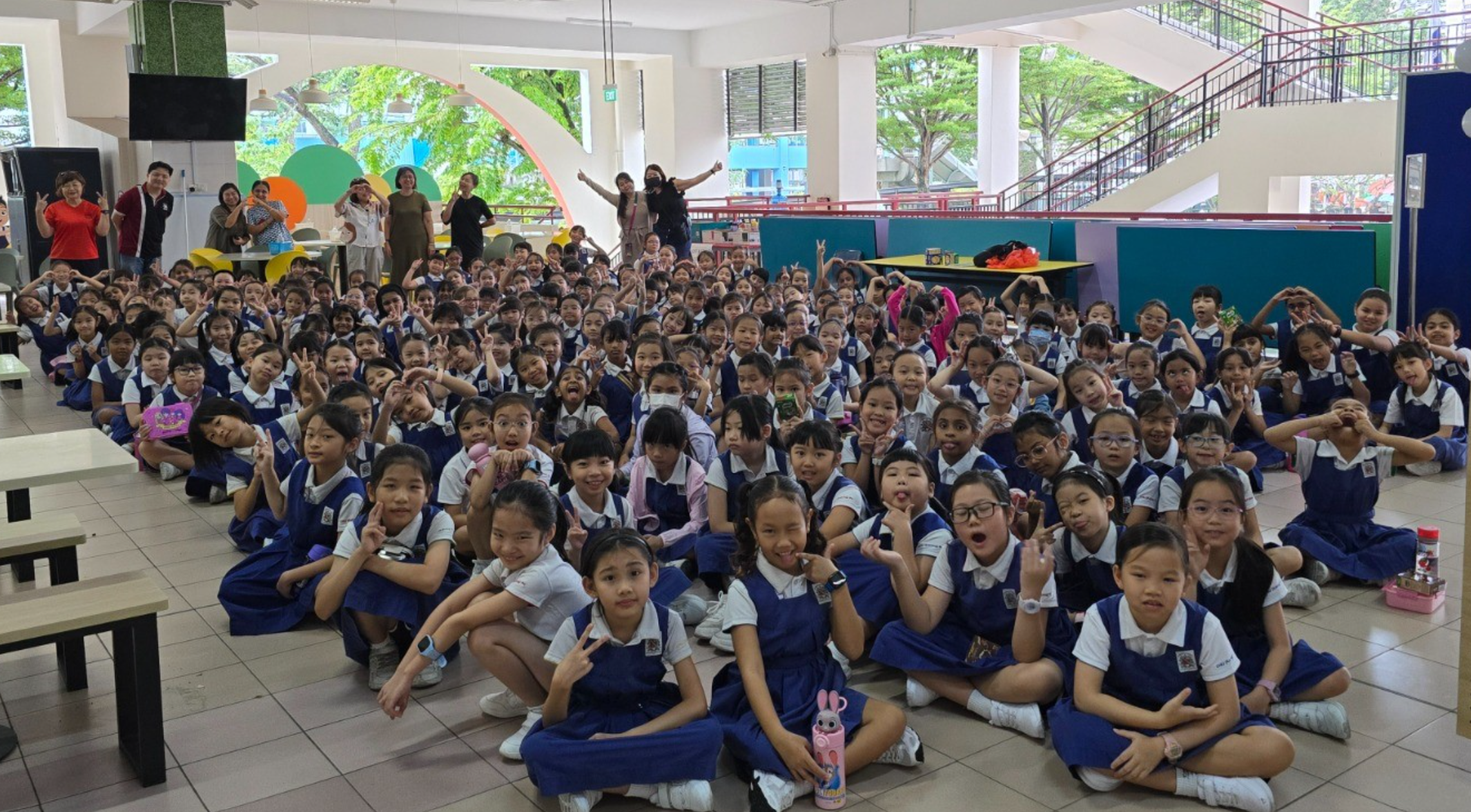 Students posing for a picture with their teachers in school canteen