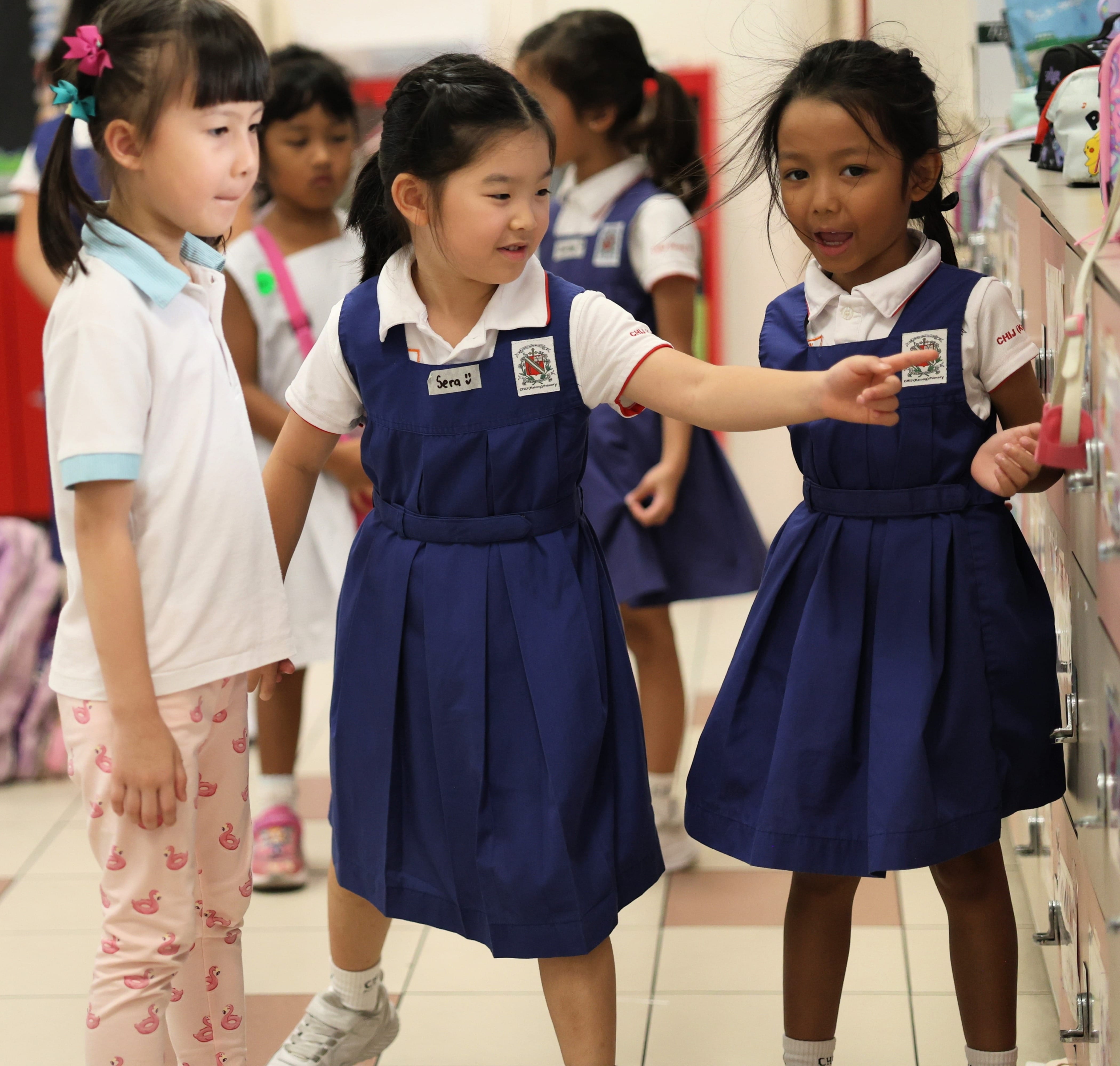 Students showing their classroom to the visiting girls