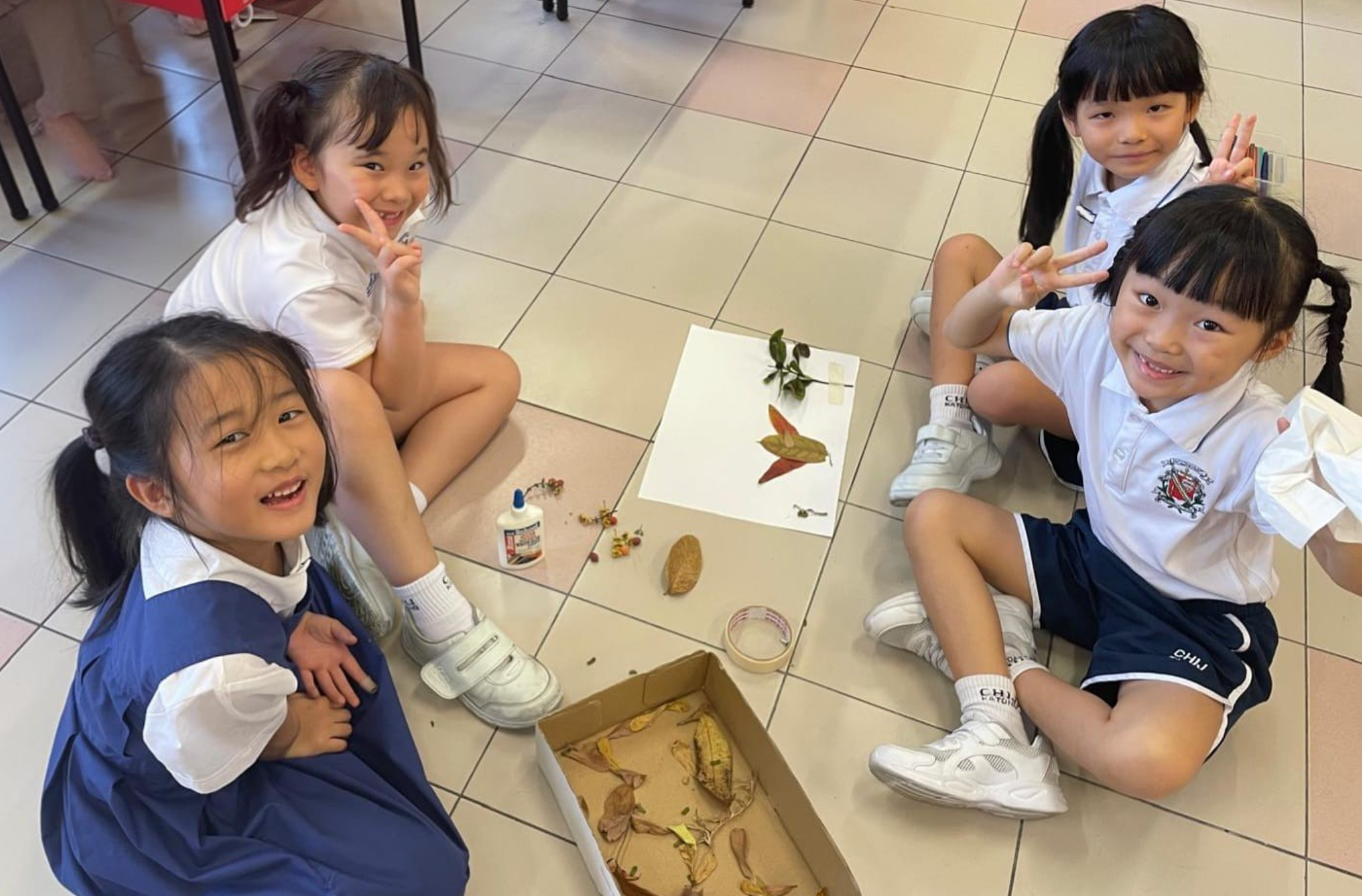 Students preparing their art work using dried leaves