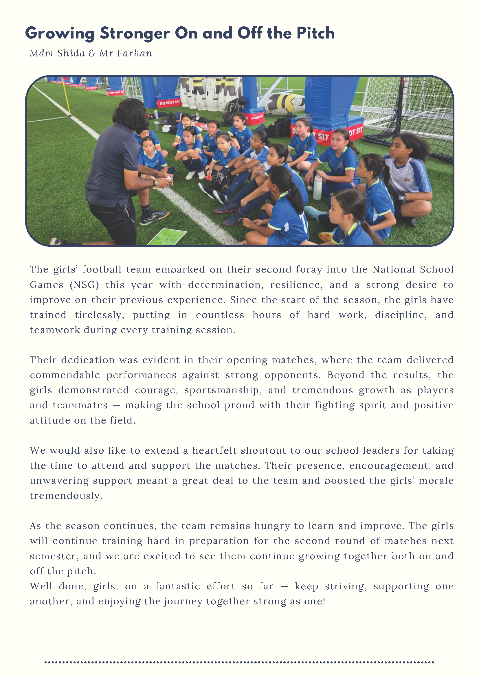 A coach speaks to a group of young girls in blue uniforms seated on a football field during a team huddle.