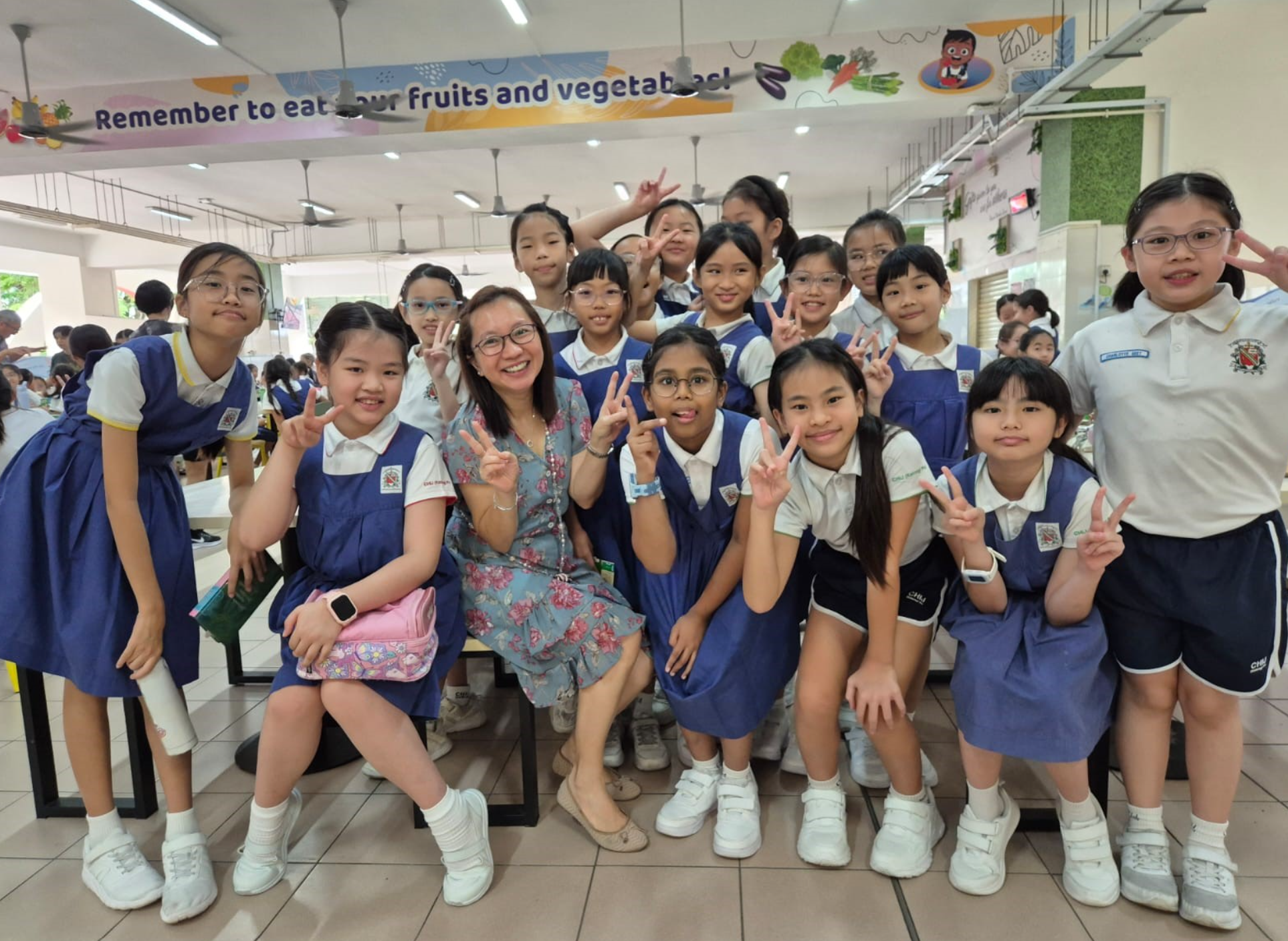 Students posing with teacher in school canteen