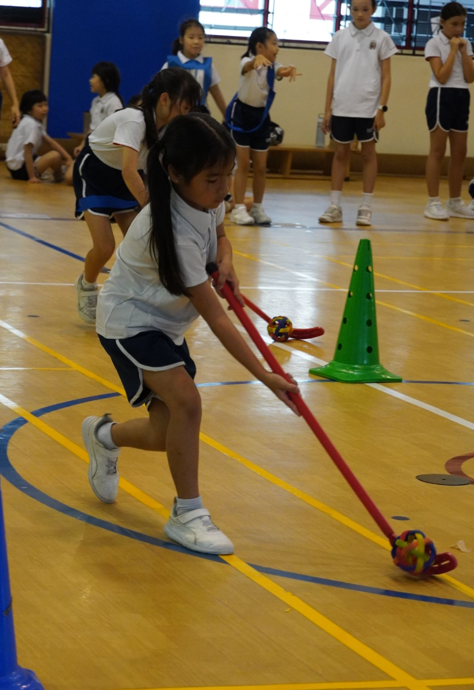 IJ girl dribbling with floorball stick during Lower Primary Games day