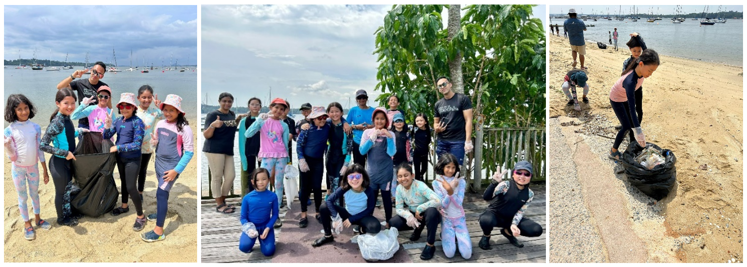 Groups of children and adults pose on a beach and boardwalk holding trash bags during a beach cleanup event.