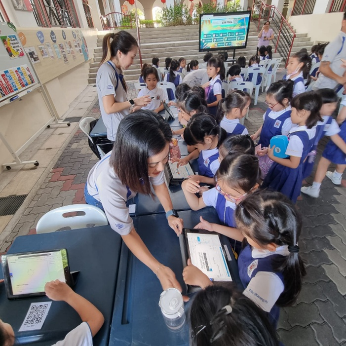 IJ girls using iPads with parent volunteers assisting during recess activy