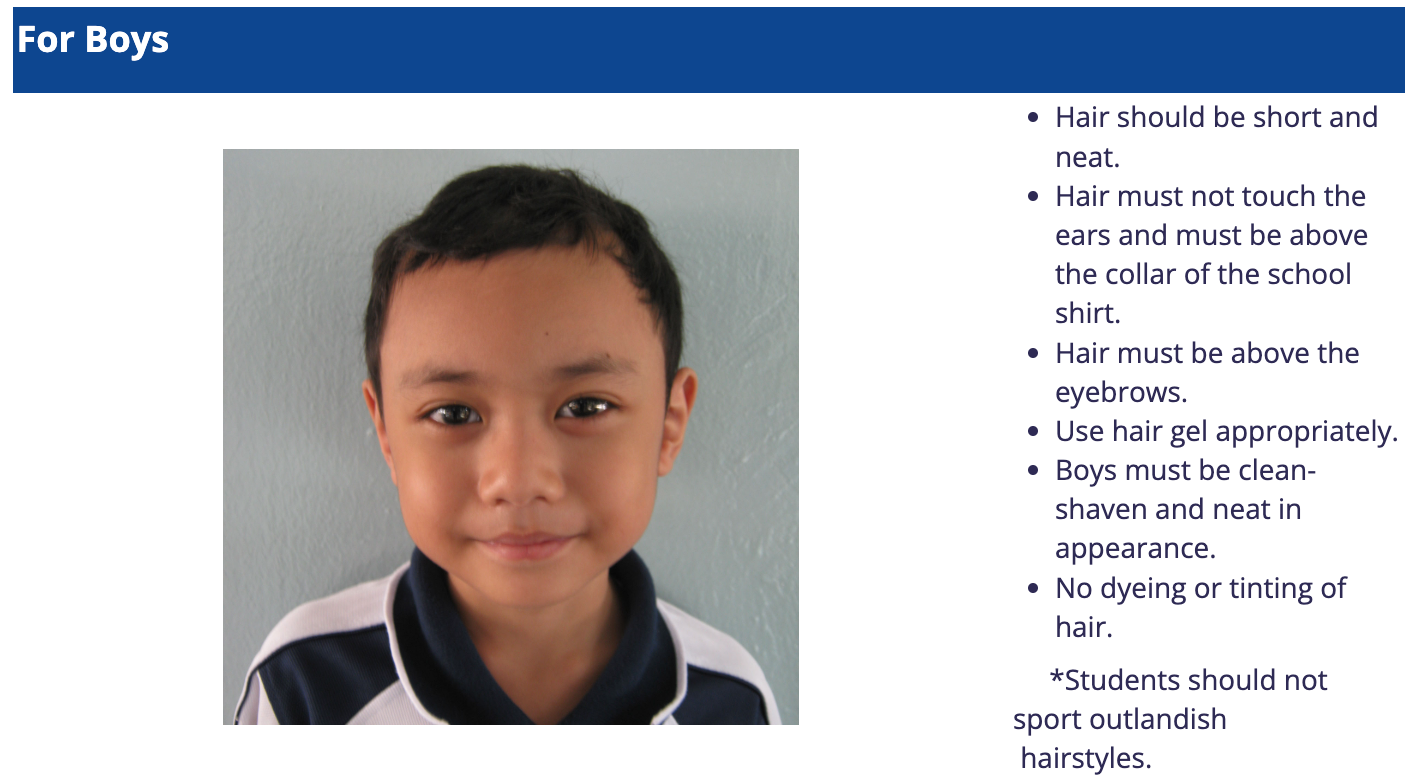 A young boy with short neat dark hair wearing a navy and white school uniform, shown as an example for boys grooming rules.