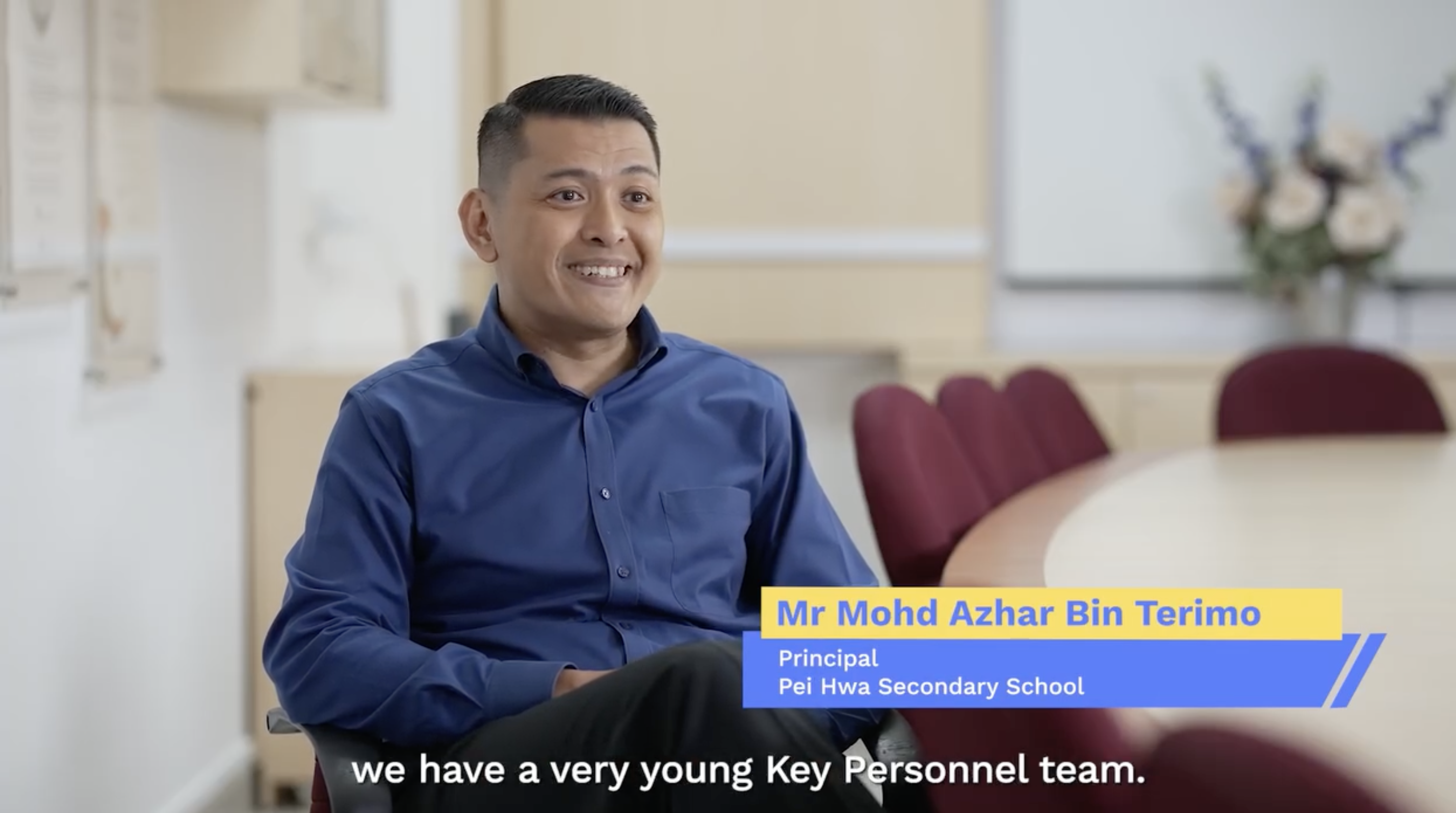 Mr Mohd Azhar Bin Terimo, Principal of Pei Hwa Secondary School, smiling in a blue shirt during an interview.