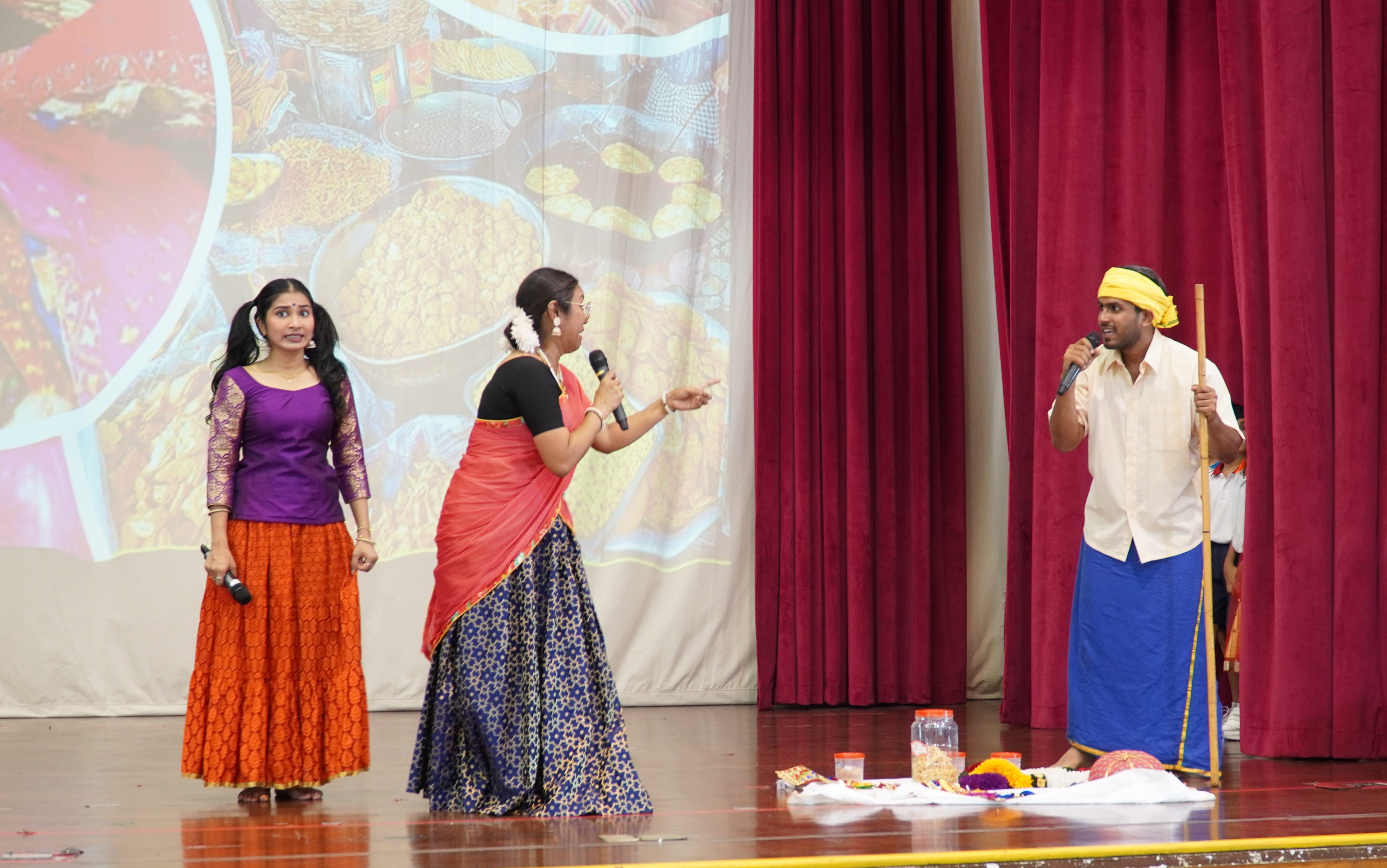 Three actors performing a skit for Deepavali