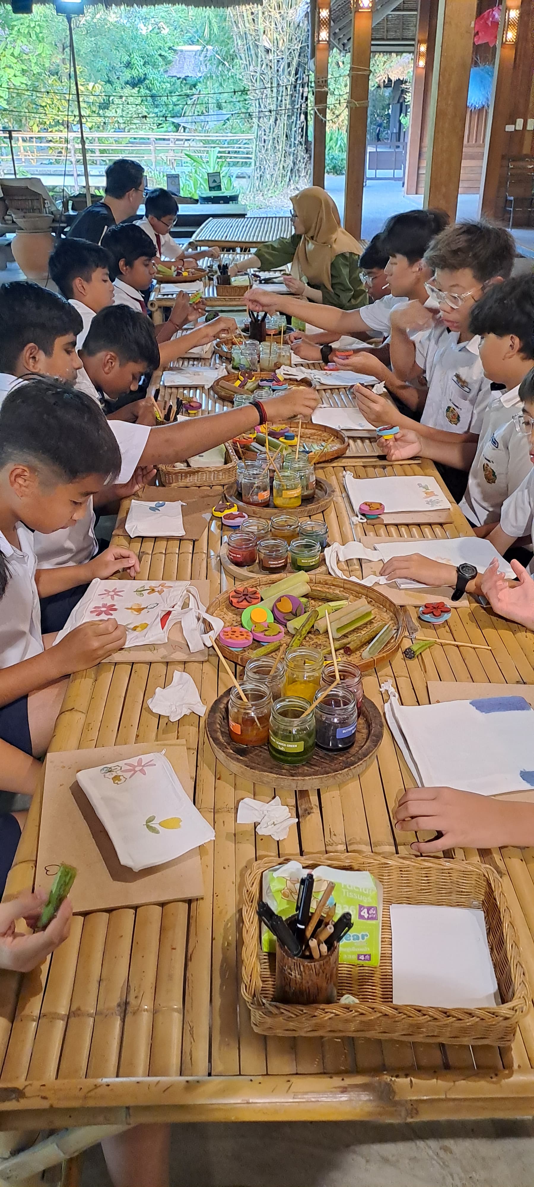 Students and teachers having a meal on a table made of bamboo