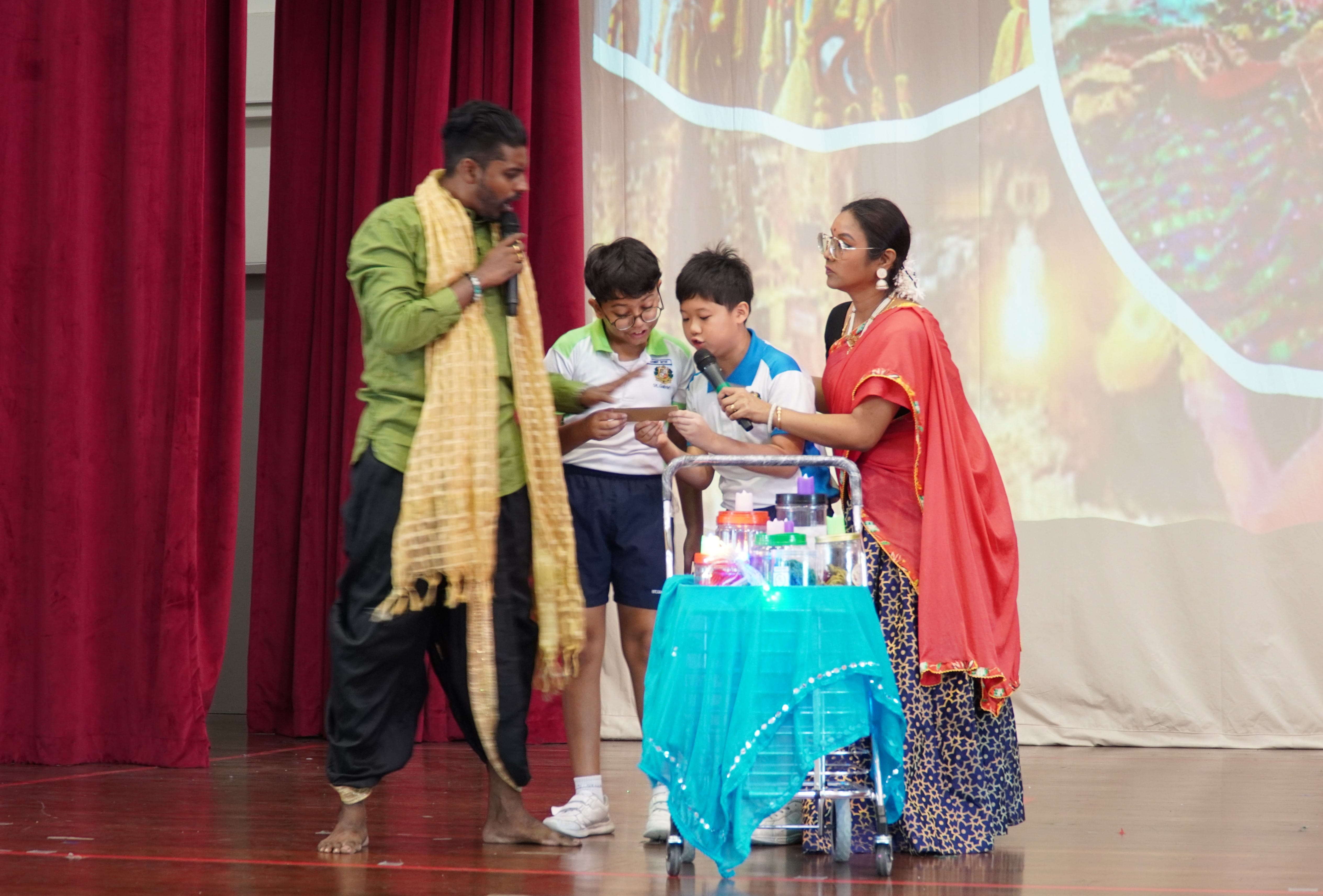 Two actors and students performing a skit for Deepavali