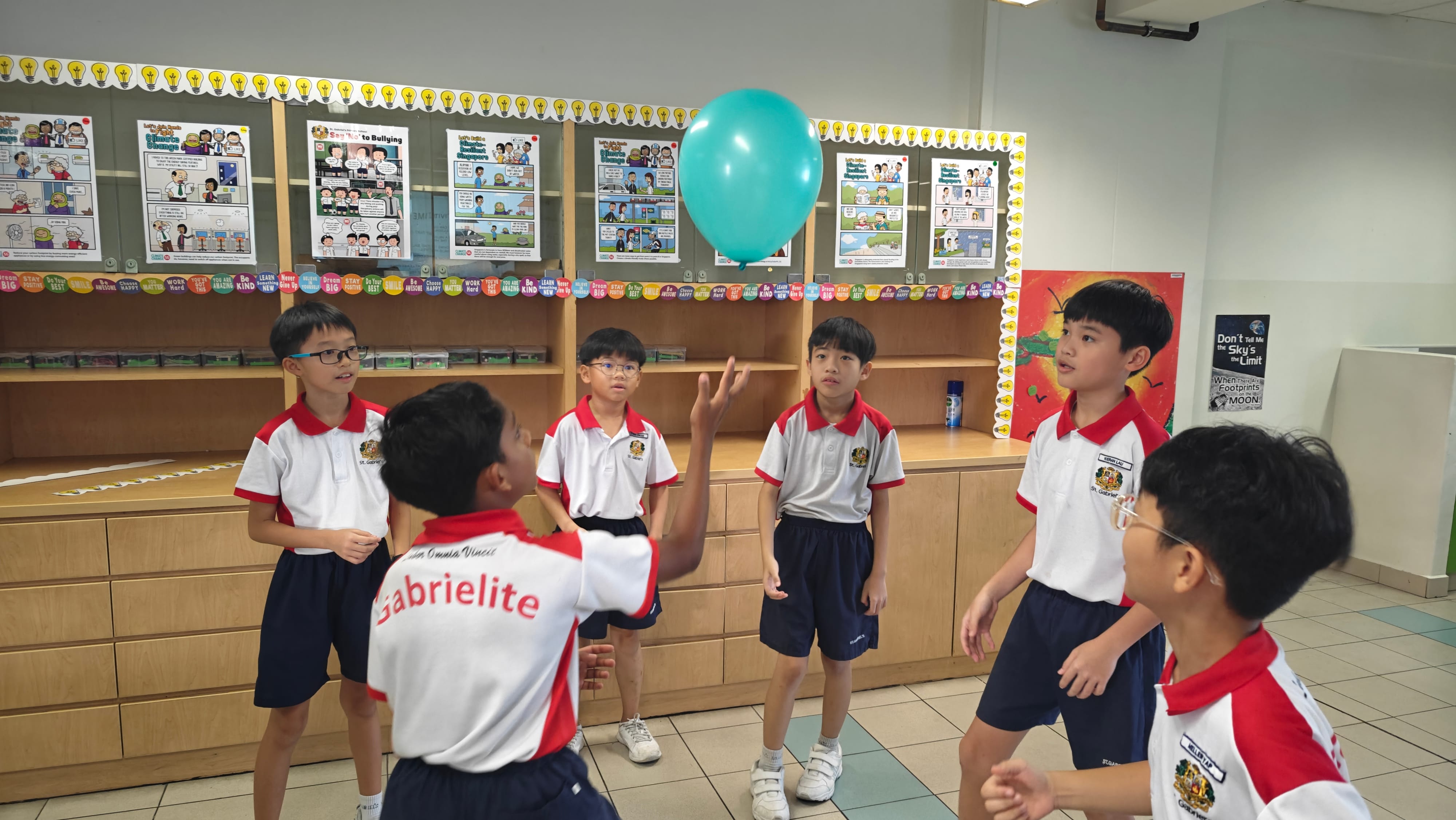 Students playing with a balloon standing