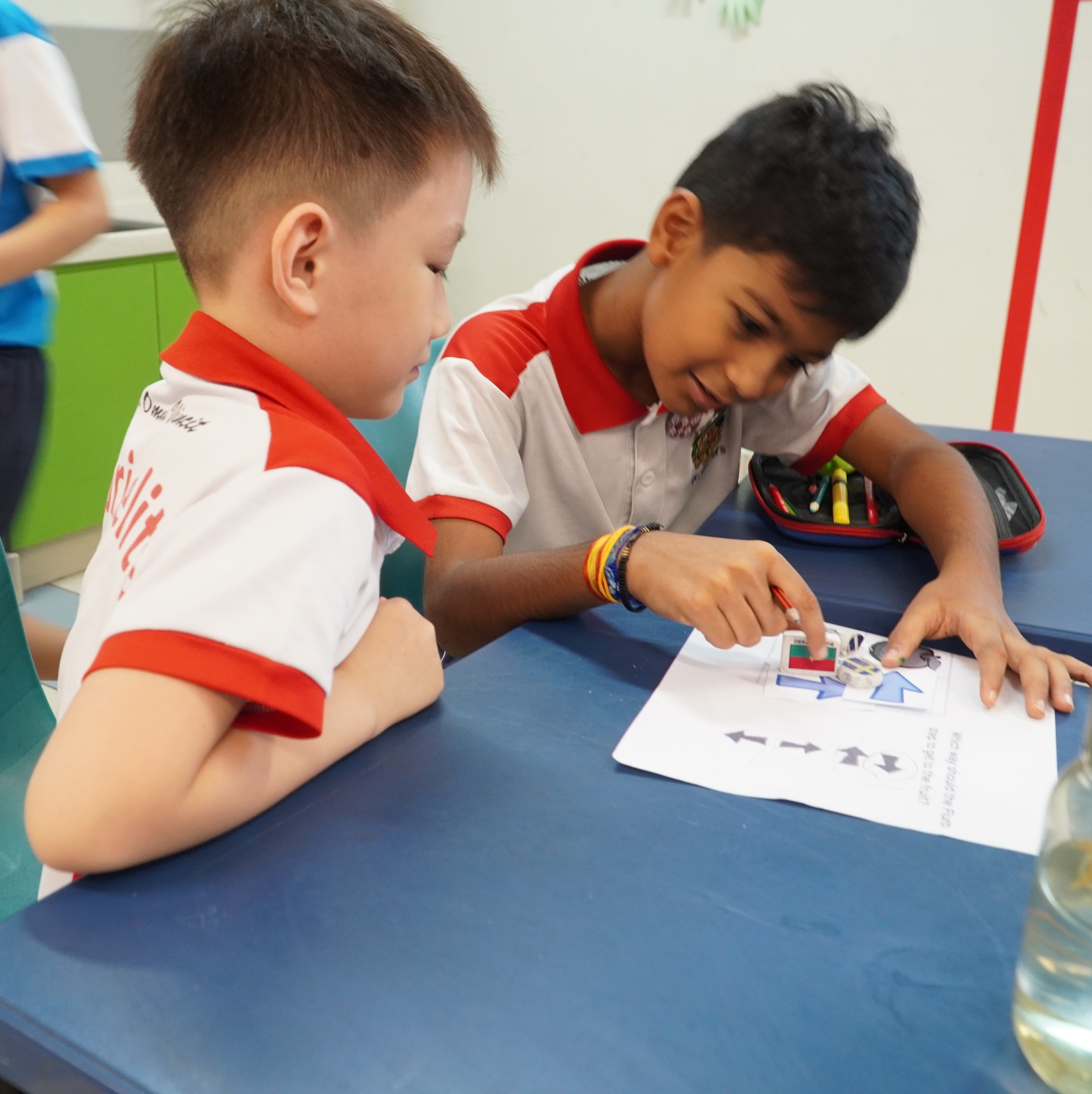 Two students working on a drawing activity on the table