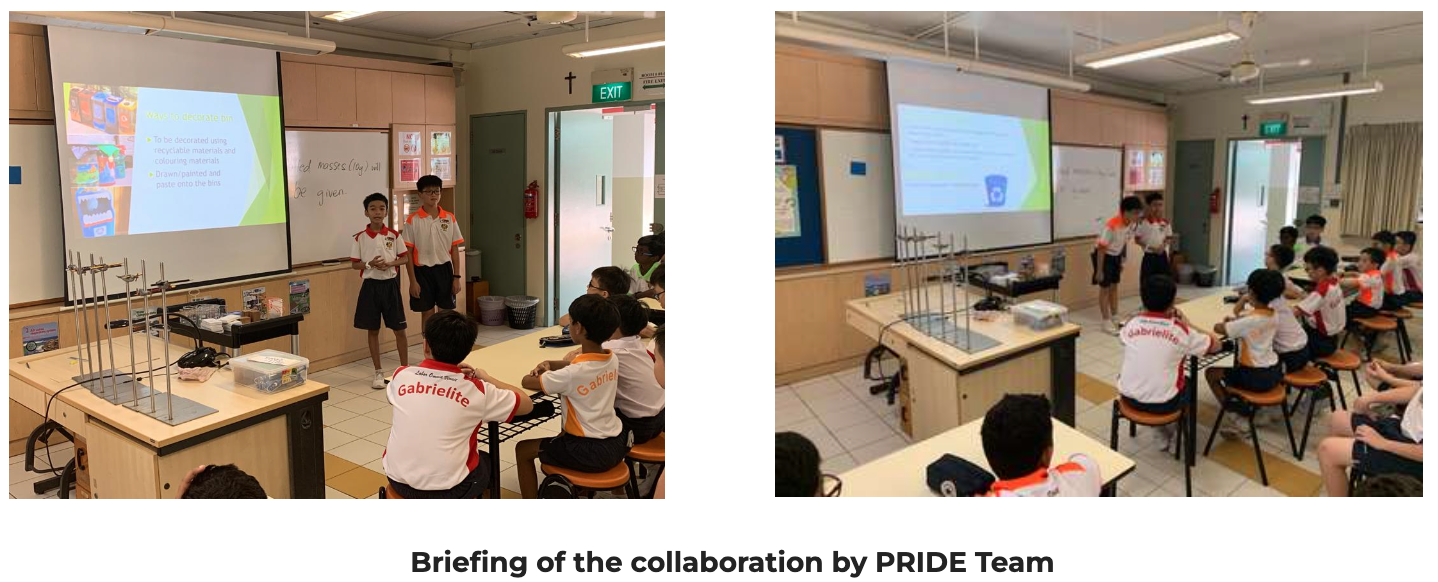 Two students in white uniforms present a slideshow to classmates seated in a school science classroom.