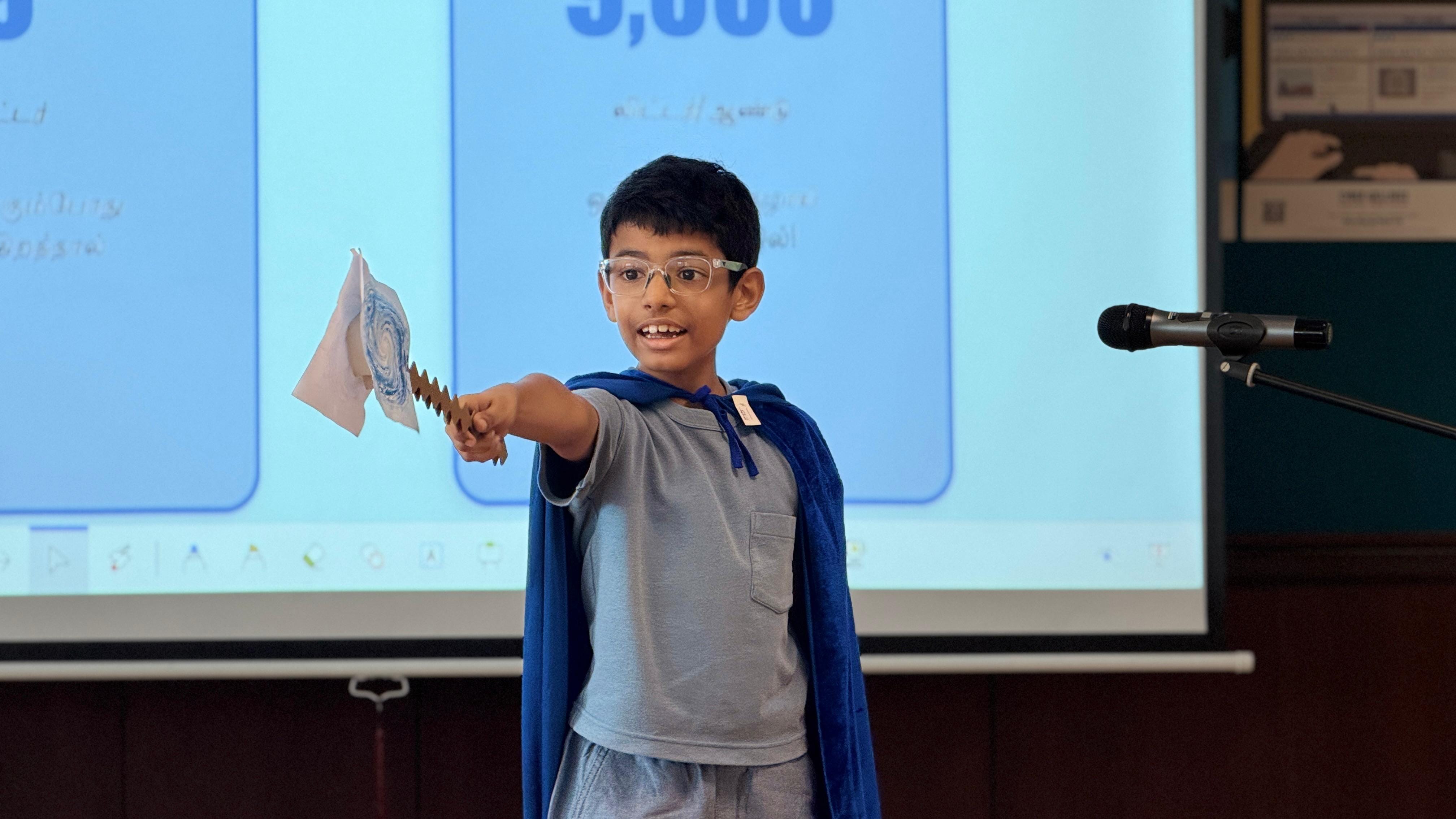 A student dressed as a superhero asking viewers to conserve energy