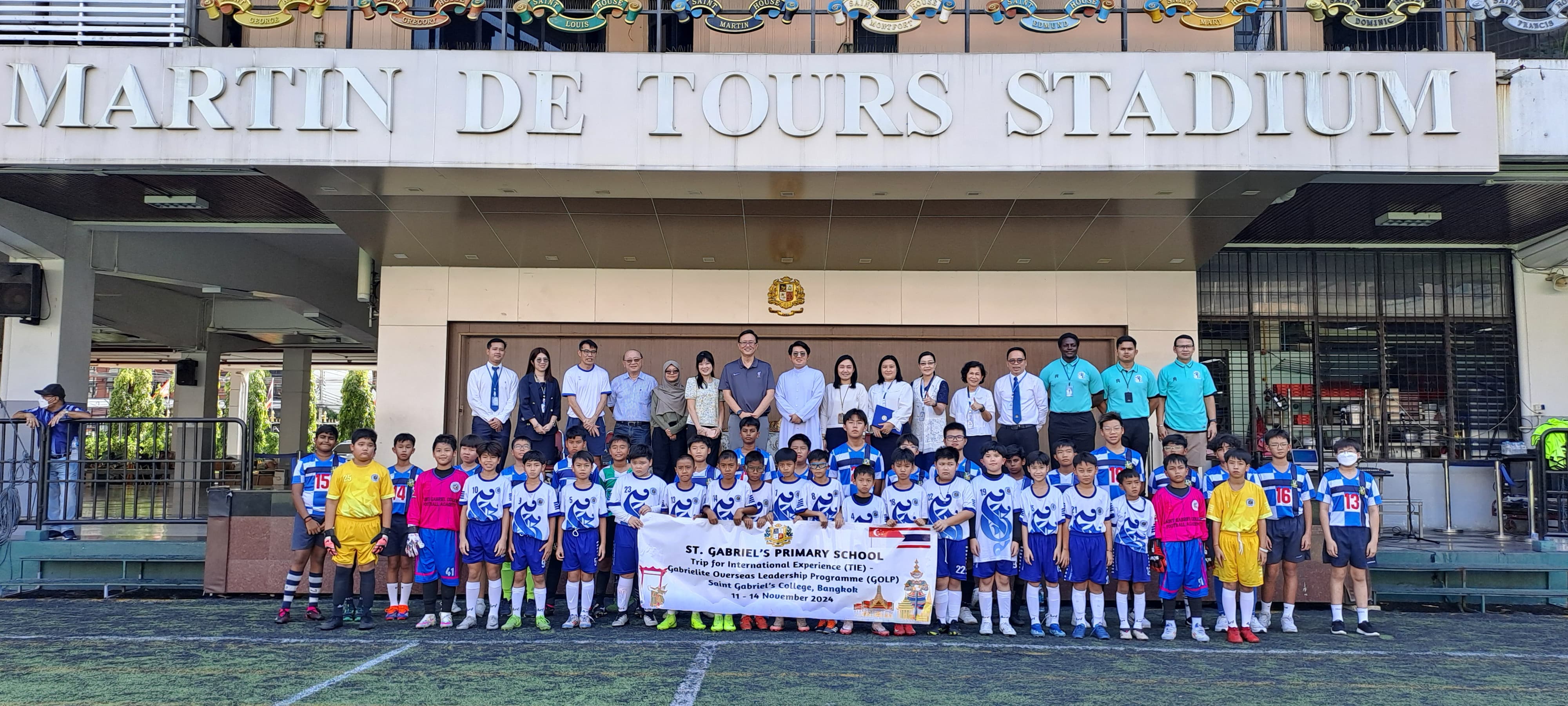 Group photo of students and teachers at the stadium