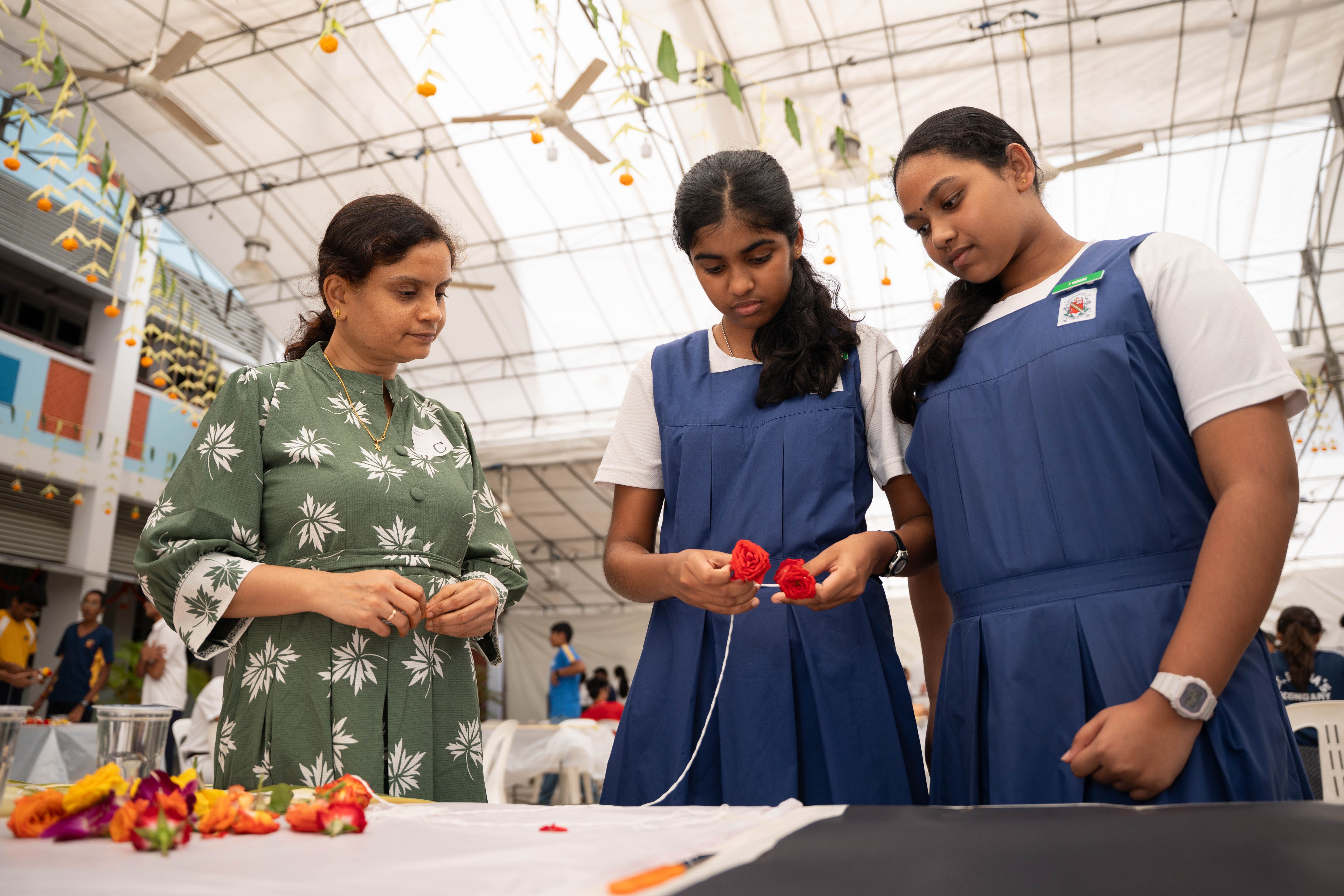 Parent guiding two students during a hands-on activity at UPTLC’s Pongal Day 1 Celebration 2026.